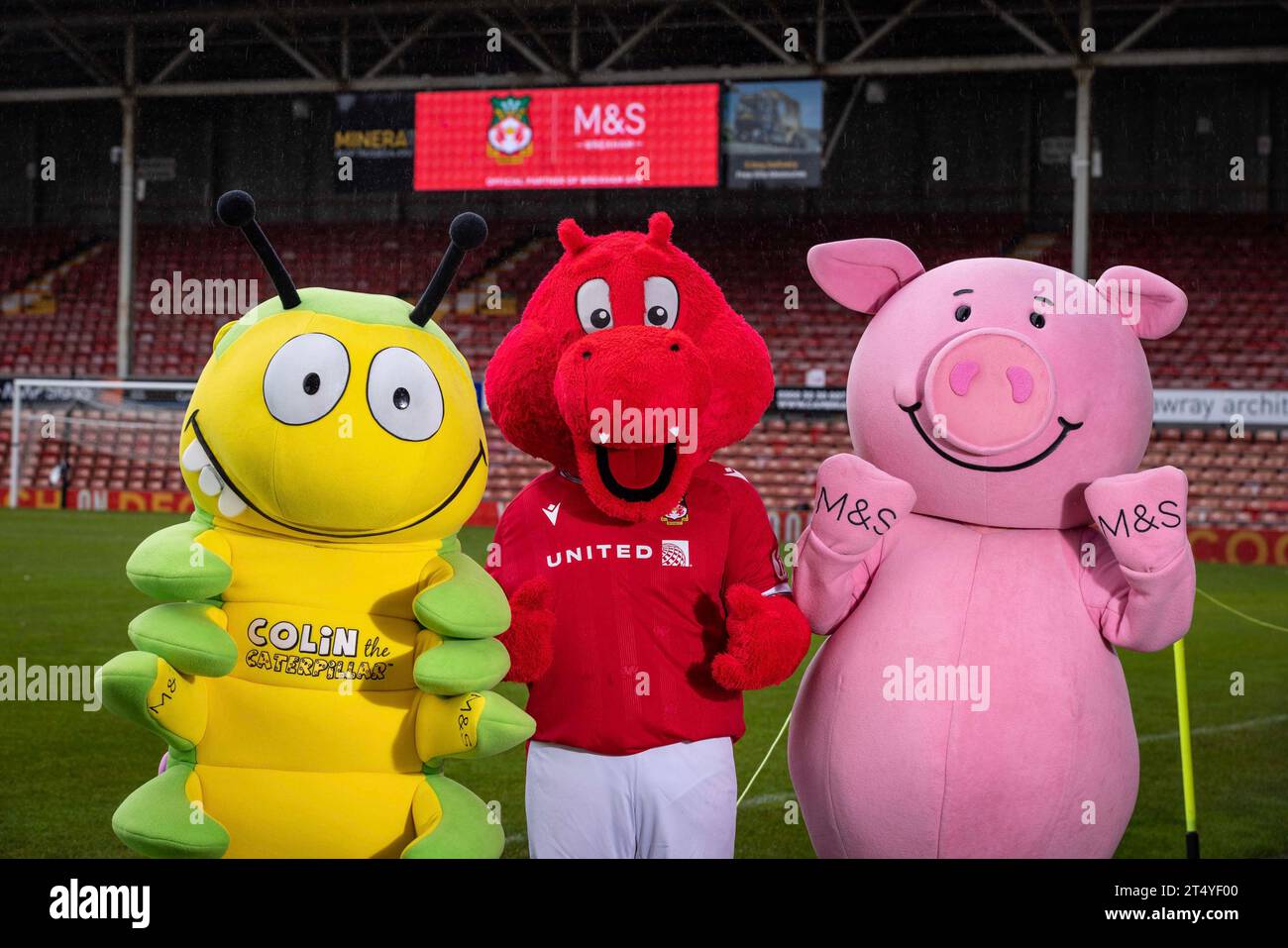 NUR REDAKTIONELLE VERWENDUNG (von links nach rechts) Colin the Caterpillar, WREX the Dragon und Percy Pig auf dem Rennplatz, um eine mehrjährige Partnerschaft zwischen Marks and Spencer (M&S) und dem Fußballverein als Co-Vorsitzende von Wrexham FC zu gründen. Rob McElhenney und Ryan Reynolds begleiten Dawn French bei der diesjährigen M&S Food Christmas-Werbekampagne. Bilddatum: Donnerstag, 2. November 2023. Stockfoto