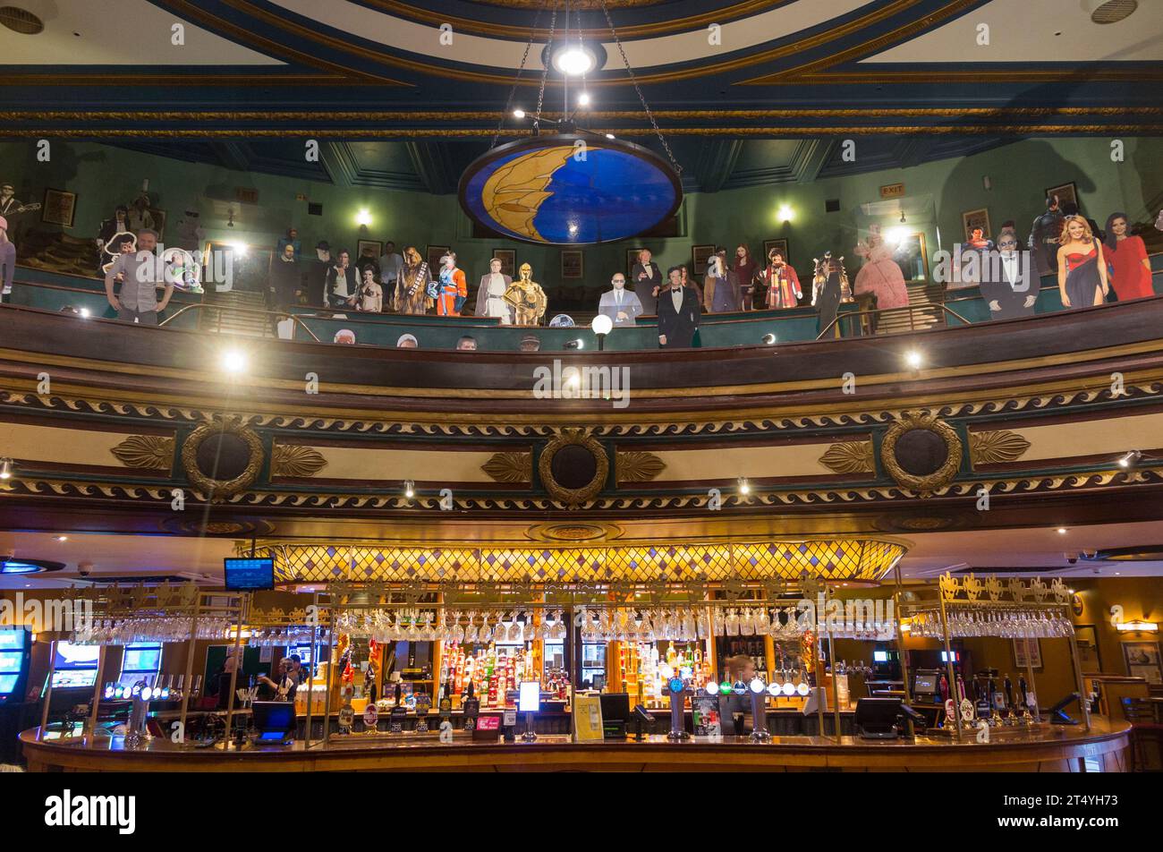 Sitzplätze und Schaufensterpuppen über der Bar im Playhouse Wetherspoon Pub, Colchester. Das öffentliche Haus war ein Theater, Kino, Bingo Hall. UK. (136) Stockfoto