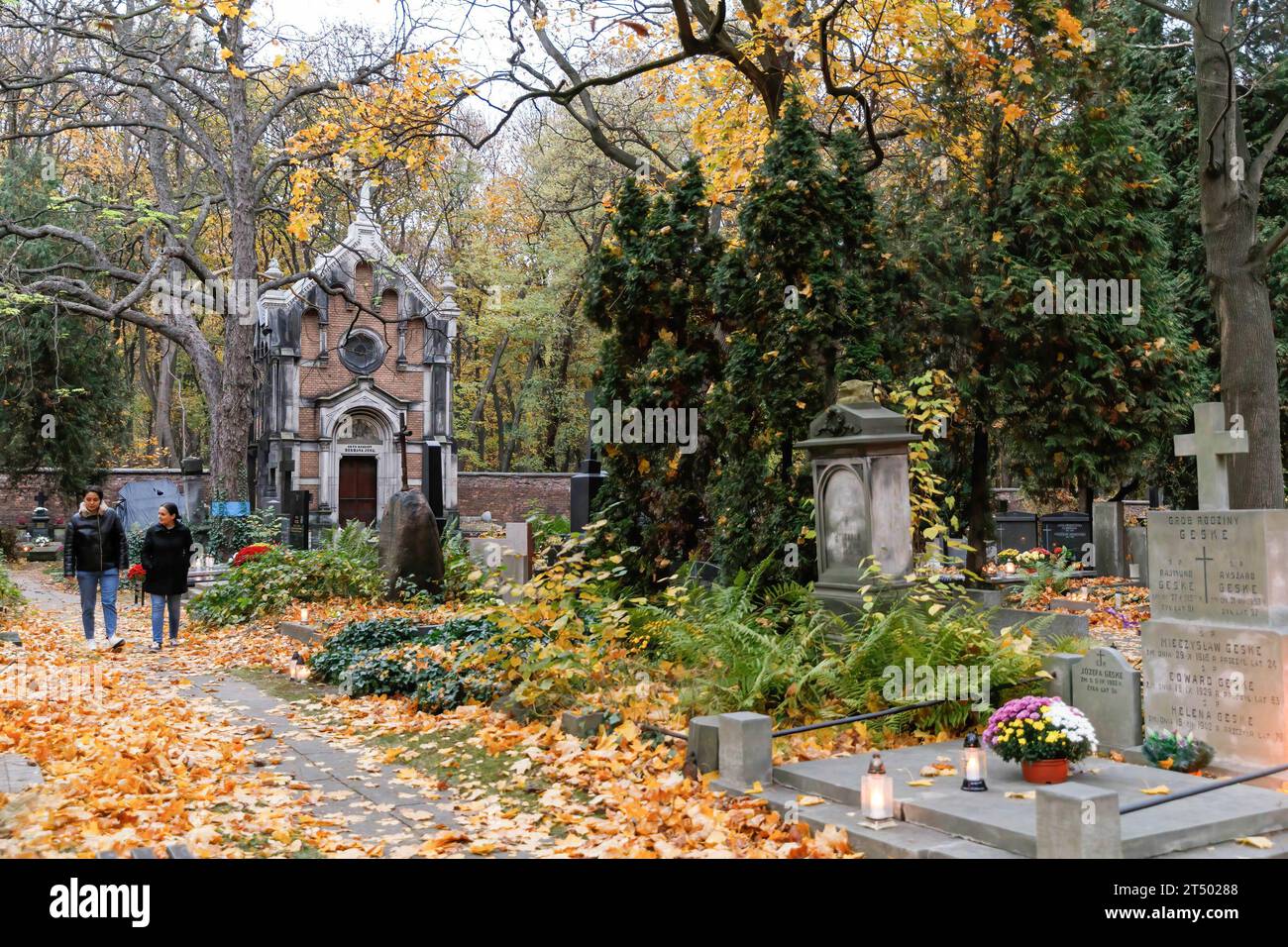 Am Allerheiligen-Tag auf dem evangelisch-Augsburger Friedhof in Warschau spazieren die Menschen durch den Friedhof. Allerheiligen (oder Dzie? Zaduszny (Polnisch) ist ein Feiertag in Polen. Es ist eine Gelegenheit, an verstorbene Verwandte zu erinnern. An diesem Tag bringen die Menschen Blumen, typischerweise Chrysanthemen, und Kerzen auf Friedhöfe. Der gesamte Friedhof ist voller Lichter in der Dunkelheit. Der Evangelisch-Augsburger Friedhof ist ein historischer lutherischer evangelischer Friedhof im Westen von Warschau. Seit seiner Eröffnung im Jahr 1792 wurden dort mehr als 100.000 Menschen begraben. Stockfoto