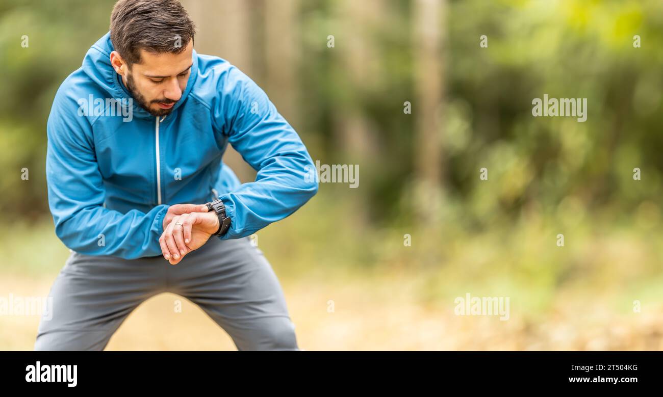 Ein junger Athlet überprüft seine Herzfrequenz auf einer intelligenten Uhr. Stockfoto
