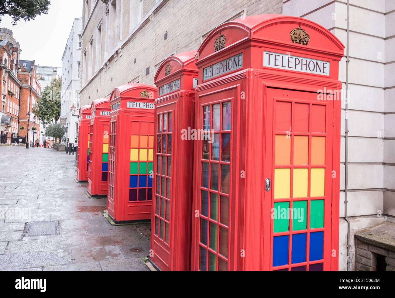 Eine Reihe klassischer K6-Telefonboxen in Rot, dekoriert mit LGBTQ-Regenbogenfarben in Broad Court, Covent Garden, London, England, Großbritannien Stockfoto