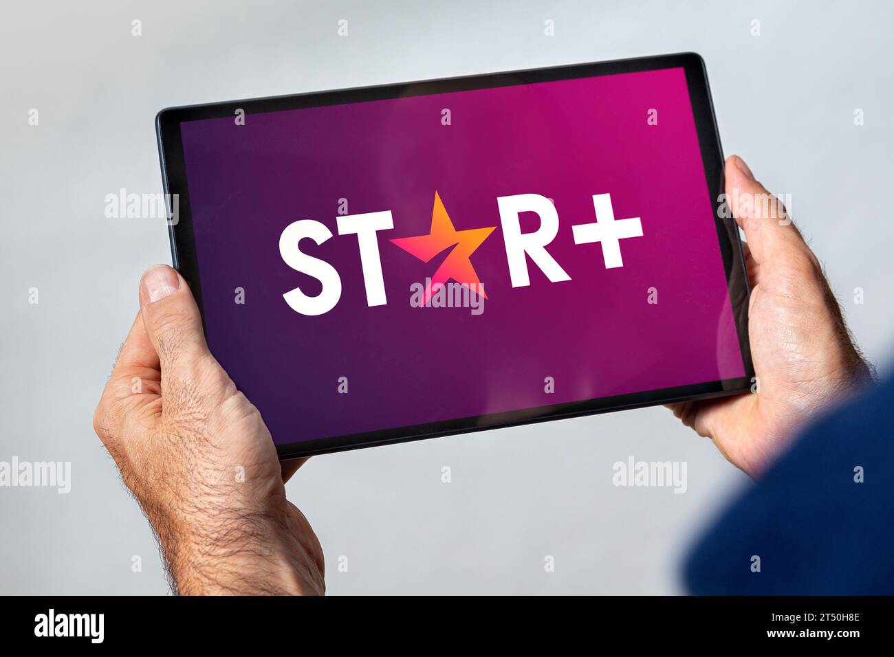 Mann, der ein Tablet mit dem Star Plus-Video-Streaming-Service-Logo auf dem Bildschirm hält. ROSARIO, ARGENTINIEN - 2. NOVEMBER 2023. Stockfoto