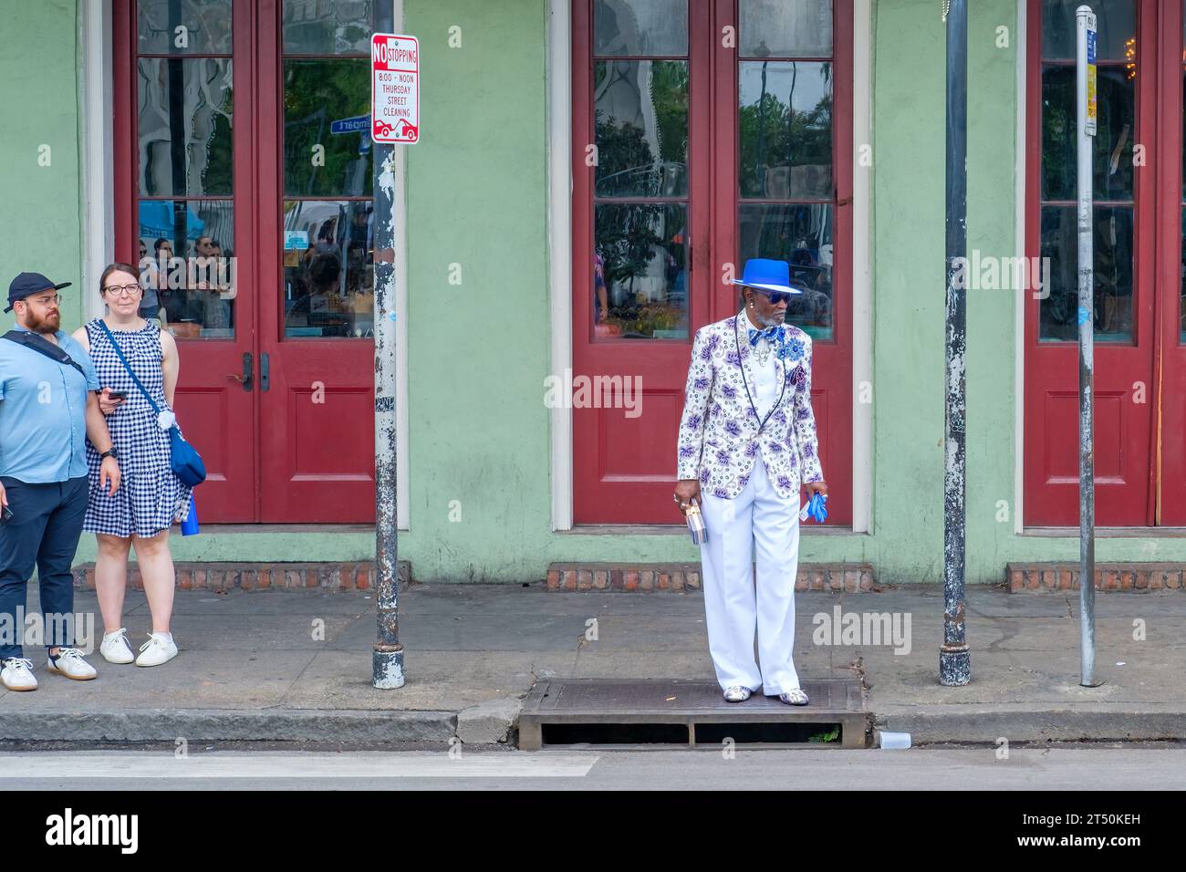 NEW ORLEANS, LA, USA - 26. MÄRZ 2023: Ein Touristen-Paar beobachtet ein modisch gekleidetes New Orleanian im Herzen des French Quarter Stockfoto
