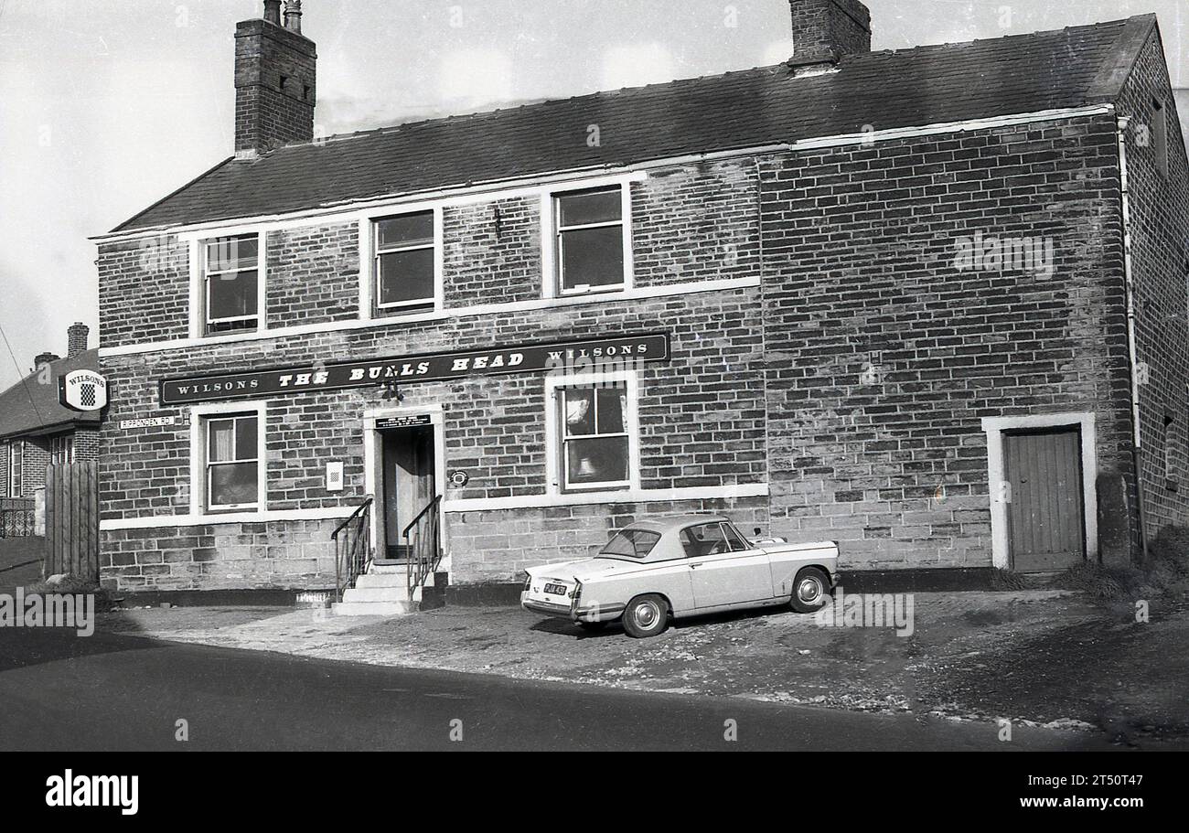 1960er Jahre, ein historischer Wagen von Triumph Herald, der vor dem Bulls Head, einem Pub der Wilson's Brewery, an der Ripponden Rd, Oldham, England, Großbritannien, geparkt wurde. Sie wurde 2015 geschlossen. Stockfoto