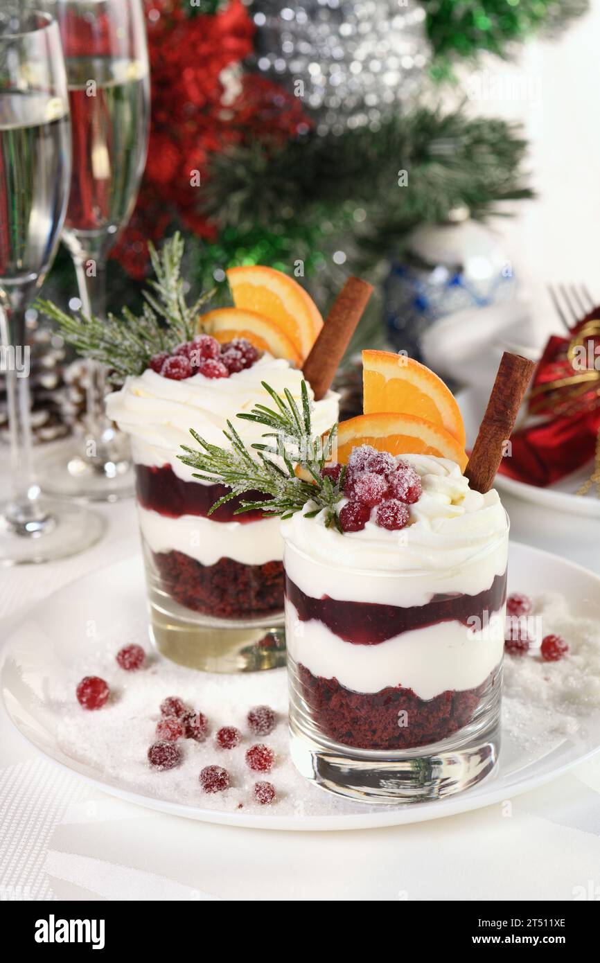 Weihnachts-Cranberry-Dessert-Tiramisu mit Mascarpone und Schlagsahne, Schokoladen-Kekskrümel und Cranberry-Marmelade, garniert mit Orangenscheiben, Dose Stockfoto