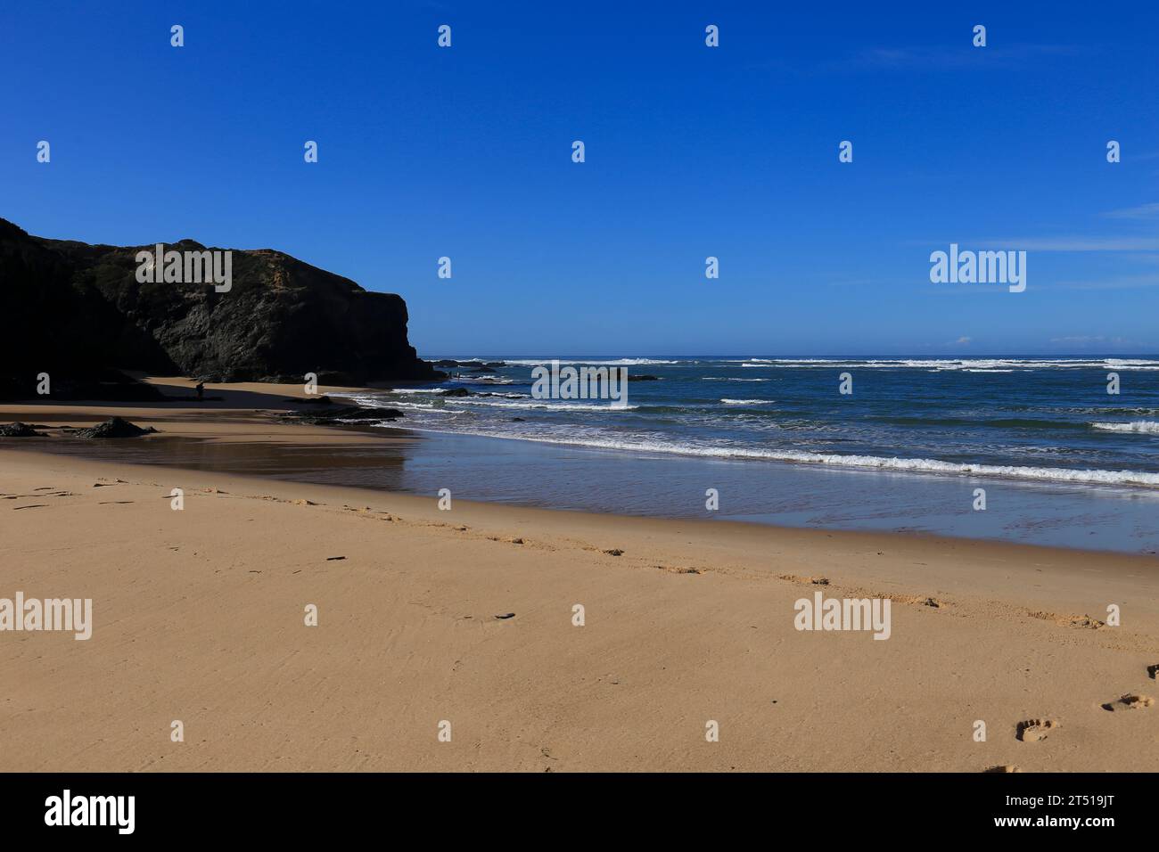 Der Strand Praia das Furnas mit schwarzen Basaltfelsen im Dorf Vilanova de Milfontes, Portugal Stockfoto