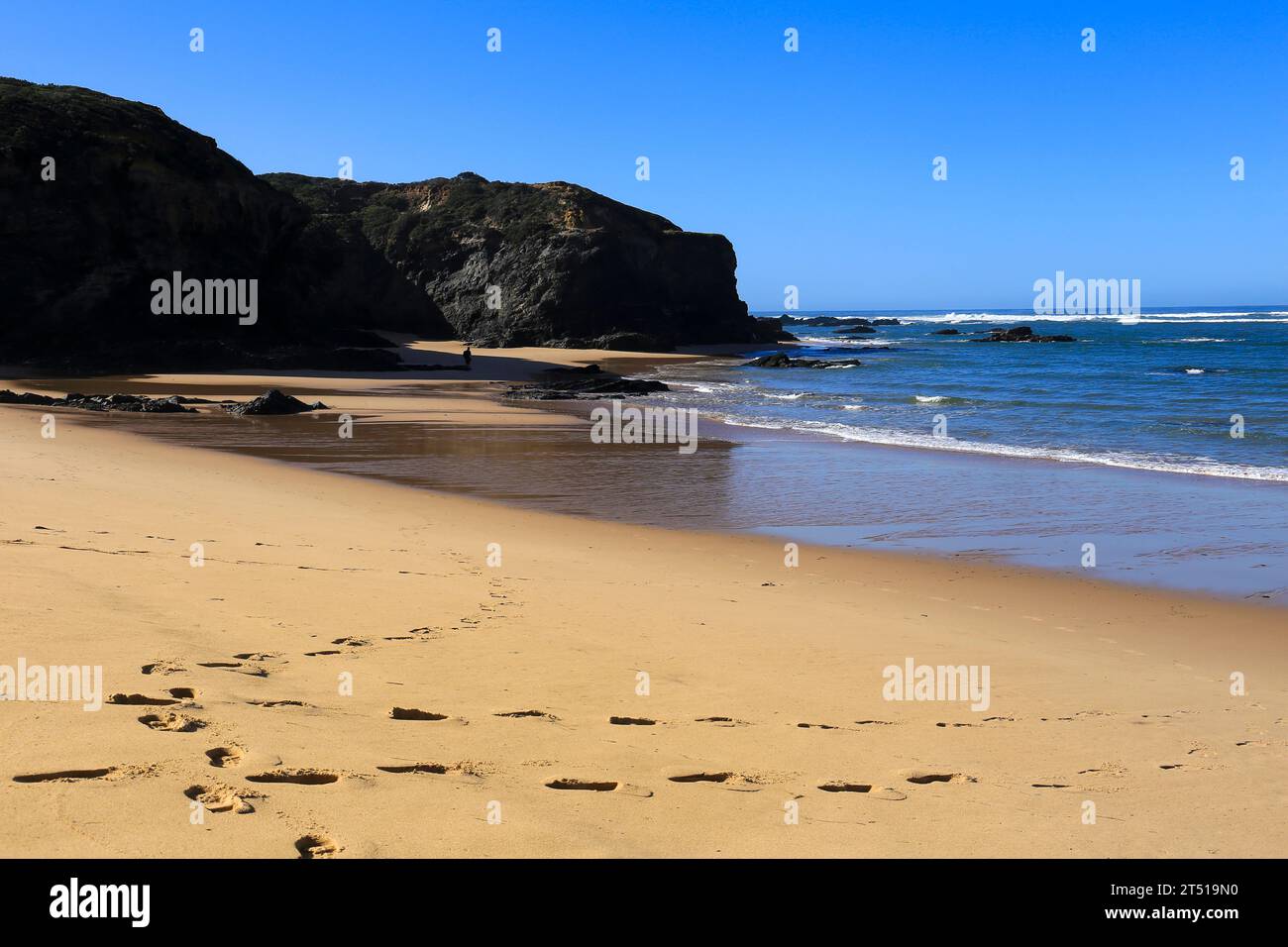 Der Strand Praia das Furnas mit schwarzen Basaltfelsen im Dorf Vilanova de Milfontes, Portugal Stockfoto