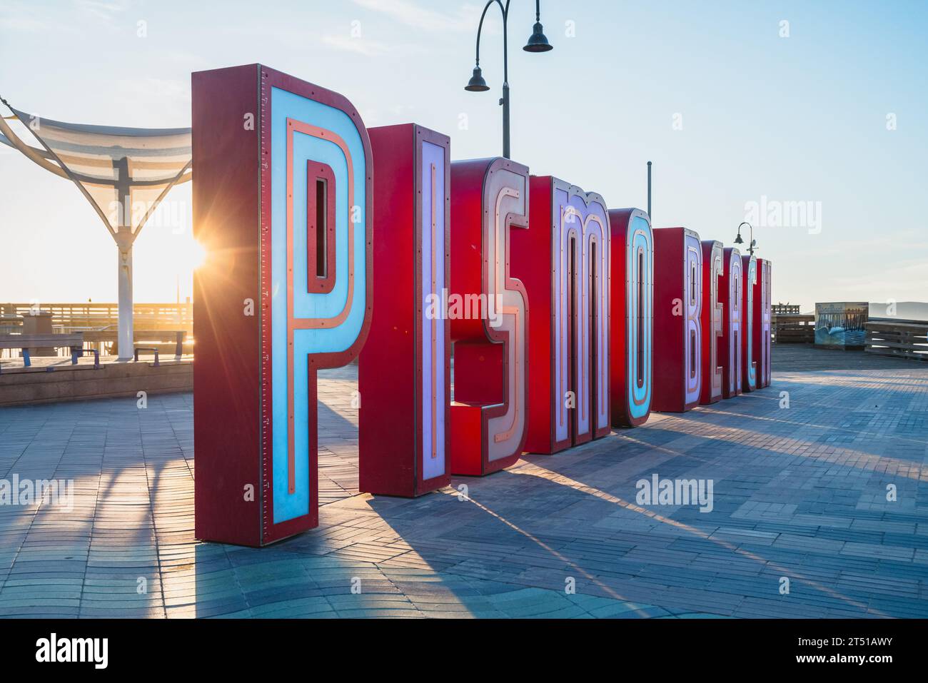 Pismo Beach, Kalifornien, USA - 1. November 2023. Pismo Beach Pier plaza bei Sonnenuntergang. Die großen aufleuchtenden Buchstaben, ein neues Neon-Wahrzeichen von Pismo Beach ci Stockfoto