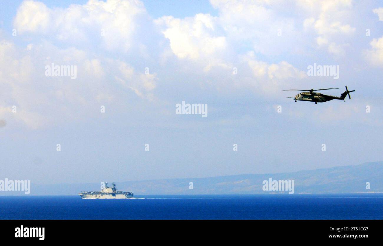 1002035214S-148 BAIE DE GRAND GOAVE, Haiti (3. Februar 2010) das amphibische Sturmschiff USS Nassau (LHA 4) operiert vor der Küste von Baie de Grand Goave, Haiti, während ein Super-Hallion-Hubschrauber CH-53E, der der Marine Heavy Helicopter Squadron (HMH) 461 zugewiesen wurde, an Bord des Mehrzweckschiffs USS Bataan einschiffte (Linkslenkung 5), fliegt über dem Kopf. Nassau führt humanitäre Hilfseinsätze und Katastrophenhilfe im Rahmen der Operation Unified Response durch, nachdem ein Erdbeben der Stärke 7,0 schwere Schäden in und um Port-au-Prince, Haiti 12. Januar verursacht hat. Marineblau Stockfoto