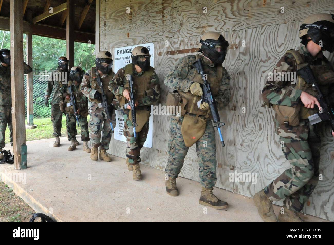 1001092978F-063 GUAM (9. Januar 2010) Seeleute, die dem Naval Mobile Construction Battalion (NMCB) 1 zugewiesen sind, und Marines, die dem Anti-Terror Security Team der Flotte, Pacific Company (FASTPAC), Bravo 1 Platoon, zugewiesen sind, bereiten sich auf ein Gebäude vor, um ein Kampftraining in der Naval Base Guam zu absolvieren. (U.S. Navy Stockfoto