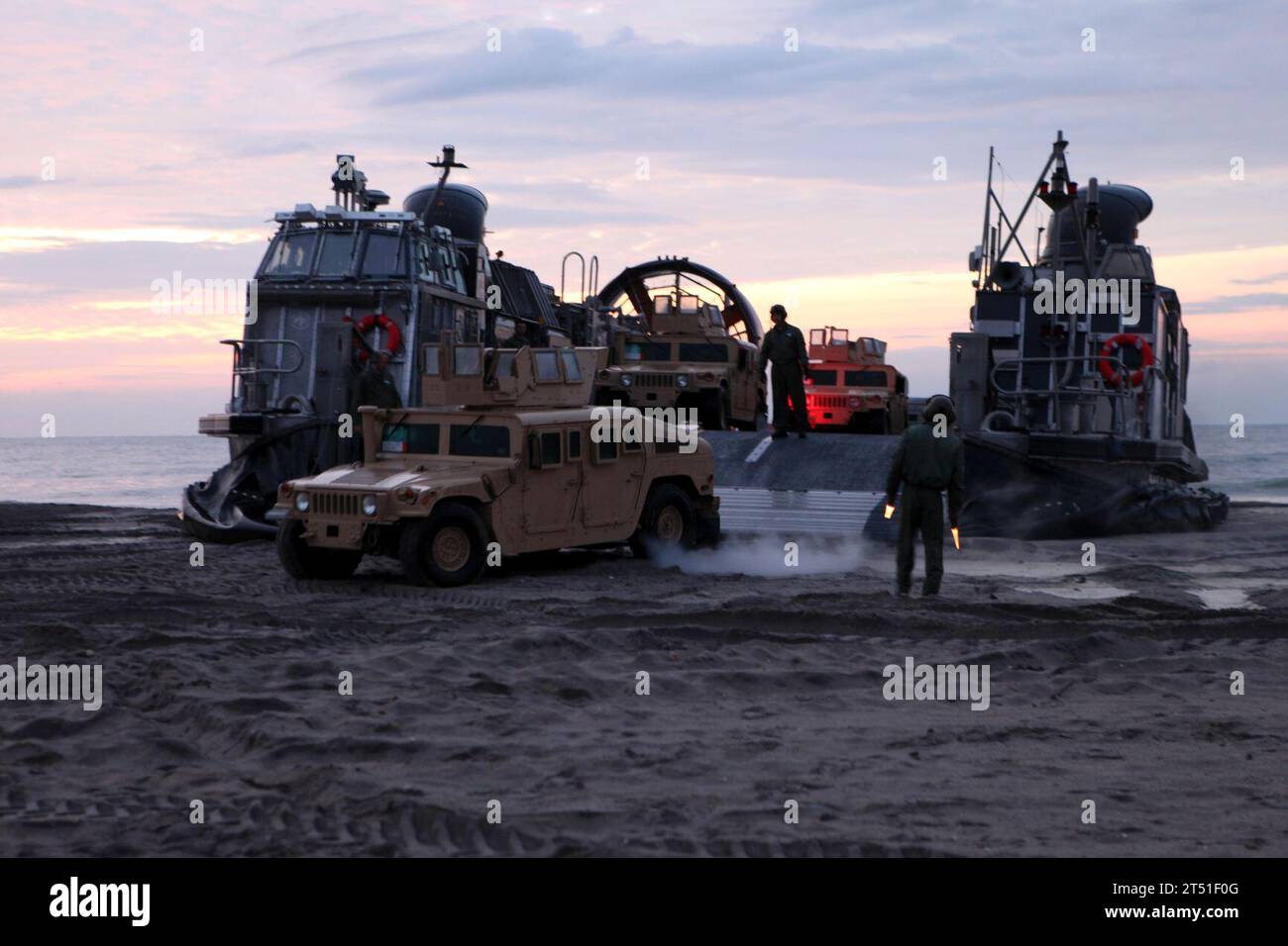 120206LZ389-099 CAMP LEJEUNE, N.C. (6. Februar 2012) Marines leiten Fahrzeuge, die während der Übung Bold Alligator 2012 von einem Landungsboot, Luftkissen (LCAC) auf dem Onslow Beach starten. Bold Alligator ist die größte amphibische Marine-Übung der letzten 10 Jahre und repräsentiert die Revitalisierung der gesamten Palette der amphibischen Operationen durch das Navy and Marine Corps. Die Übung konzentriert sich auf den heutigen Kampf mit den heutigen Kräften und zeigt die Vorteile des Seabasings auf. Diese Übung findet vom 30. Januar bis zum 12. Februar 2012 über Wasser und an Land in Virginia und North Carolina statt. #BA12 (U.S. Marine Corps Stockfoto