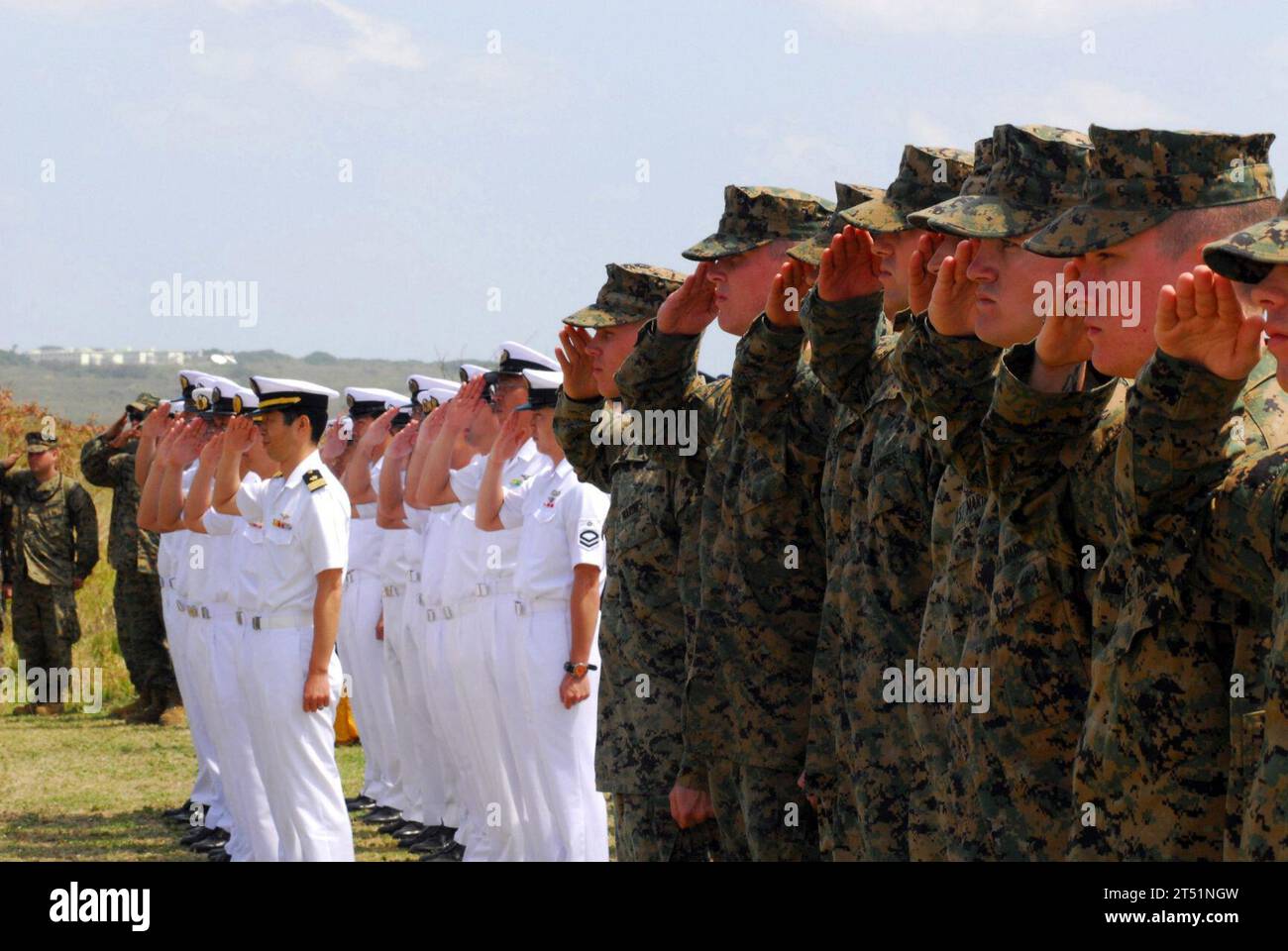 0703144124C-035 IWO JIMA, Japan (14. März 2007) - Marines grüßen zusammen mit Mitgliedern der Japan Maritime Self Defense Force (JMSDF) während der Präsentation der Farben bei der 62. Gedenkfeier der Schlacht von Iwo Jima. Die Gedenkfeier ehrte die Veteranen der Vereinigten Staaten und Japans und feierte die Einheit, die nach der Schlacht im Zweiten Weltkrieg intakt ist. Im Zusammenhang mit der Gedenkfeier hatten die Seeleute und Marines, die an Bord des Dock-Landungsschiffes USS Harpers Ferry (LSD 49) stationiert waren, die Gelegenheit, historische Überreste der Schlacht des Zweiten Weltkriegs zu sehen und zu bezahlen Stockfoto