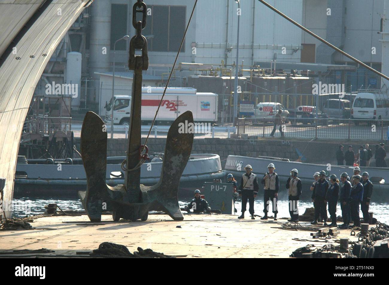 0701165387K-024 Yokosuka, Japan (16. Januar 2007) - die Seeleute des Deck Department stehen außerhalb des Steuerbordankers der USS Kitty Hawk (CV 63), während dieser am 16. Januar auf ein Lastkahn abgesenkt wird. Der Anker wurde entfernt, damit die abnehmbaren Verbindungen regelmäßig gewartet werden konnten. Kitty Hawk hat zwei Anker mit einem Gewicht von jeweils 30 Tonnen. Die Länge der Ankerkette beträgt 1.080 Fuß und jedes Glied wiegt 360 Pfund. Kitty Hawk wird von Fleet Activities Yokosuka, Japan, betrieben. US Navy Stockfoto