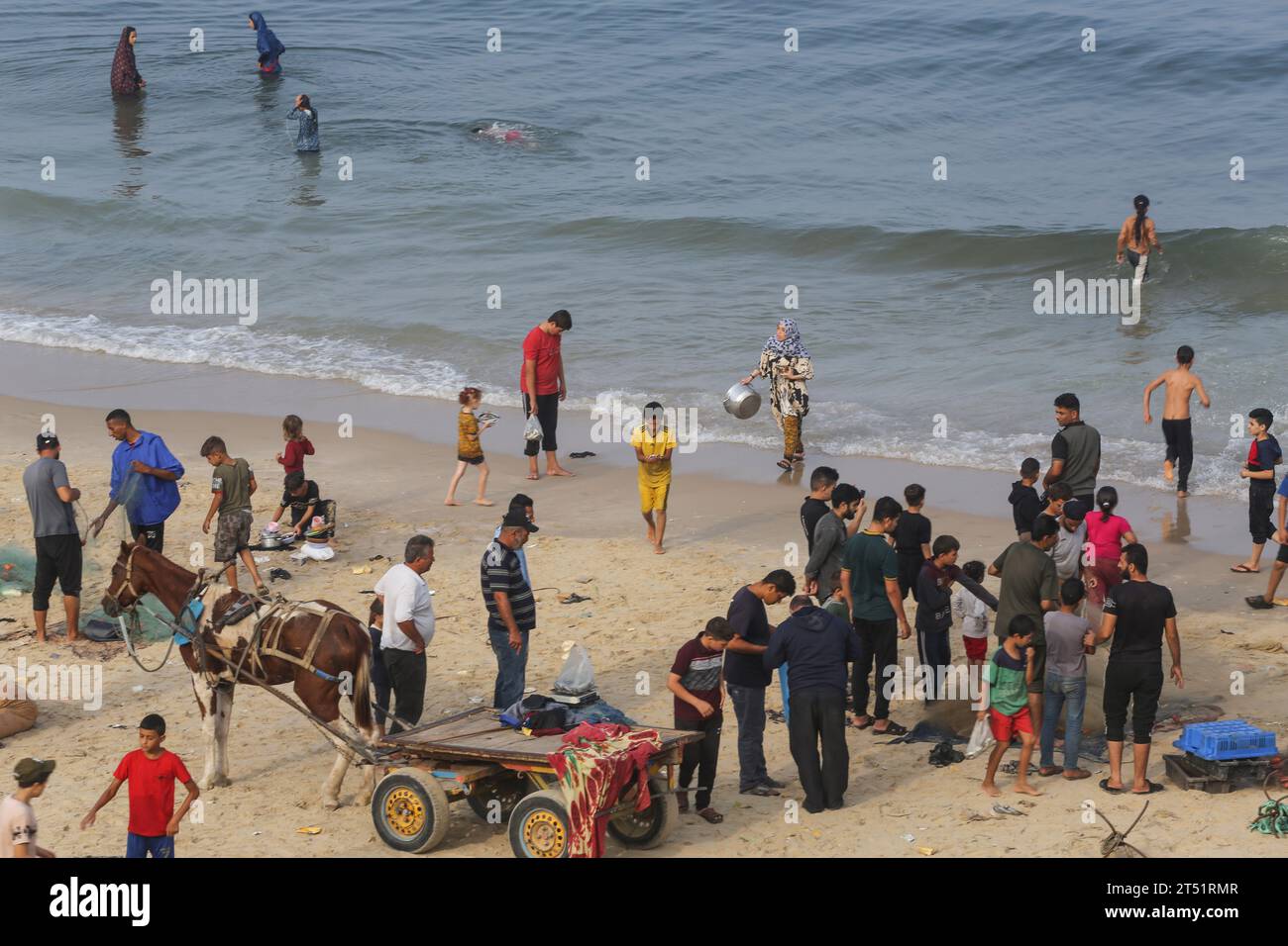 Am 29. Oktober 2023 am Strand in Deir el-Balah im südlichen Gazastreifen versammeln sich Palästinenser am Strand, um zu baden, ihre Wäsche zu waschen und Kochgeräte mit Meerwasser zu waschen. während der anhaltenden Kämpfe zwischen Israel und der palästinensischen Gruppe Hamas. Israel schlug am 29. Oktober in einem eskalierenden Luft- und Bodenfeldzug gegen den von der Hamas regierten Gazastreifen ein, als die UNO warnte, dass die zivile Ordnung in dem belagerten palästinensischen Gebiet "zusammenbrechen" würde. Tausende Zivilisten, sowohl Palästinenser als auch Israelis, sind seit dem 2. November 2023 nach dem palästinensischen H ums Leben gekommen Stockfoto