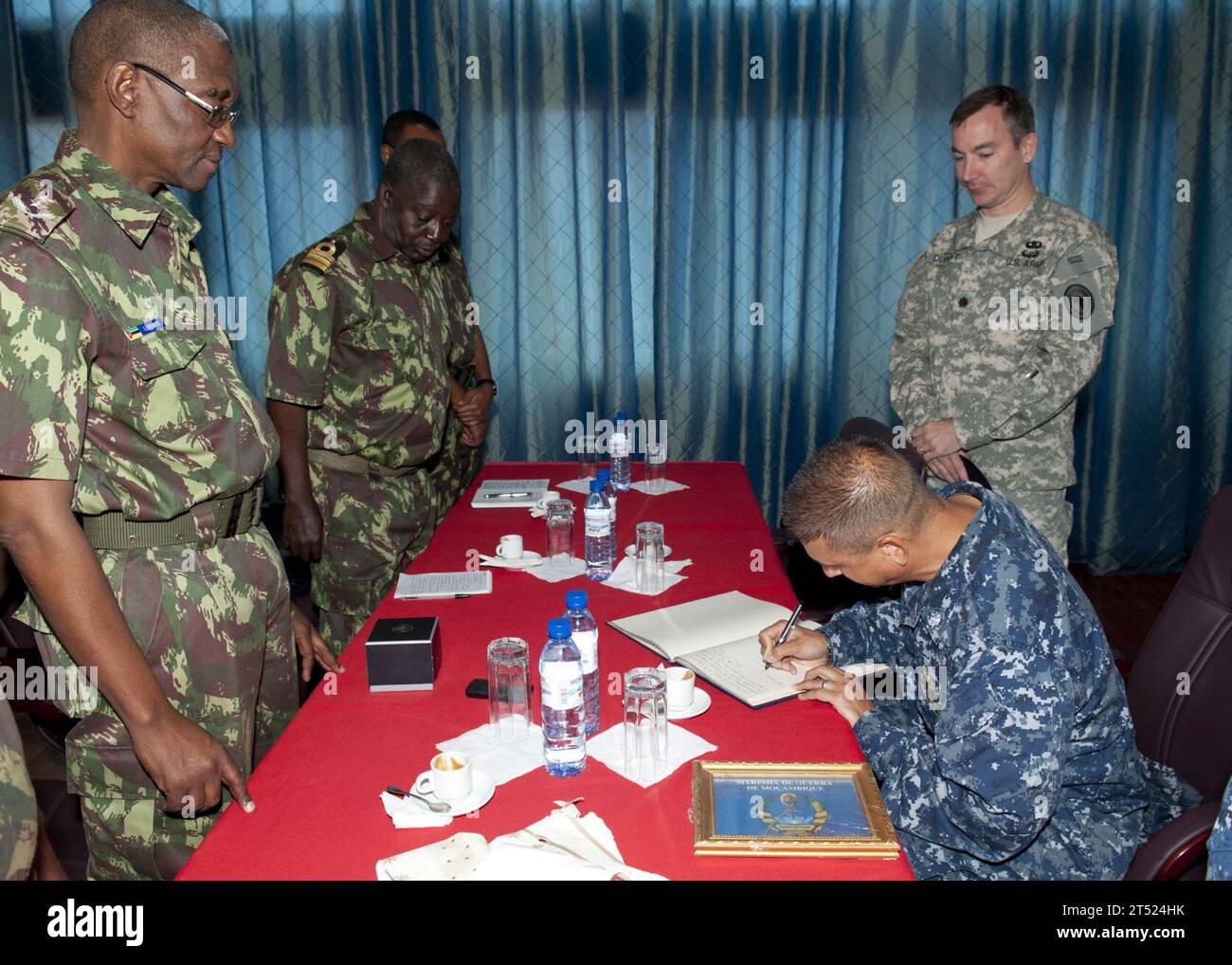 110827OV802-023 MAPUTO, Mosambik (27. August 2011) Commander. Angel Cruz, Befehlshaber der Fregatte Samuel B. Roberts (FFG 58), unterschreibt den Chef der mosambikanischen Marine Rear ADM. L.L. Menetes Gastbuch während eines Bürogesprächs. Samuel B. Roberts ist auf einem geplanten Einsatz in den Zuständigkeitsbereich der 6. US-Flotte. Marineblau Stockfoto