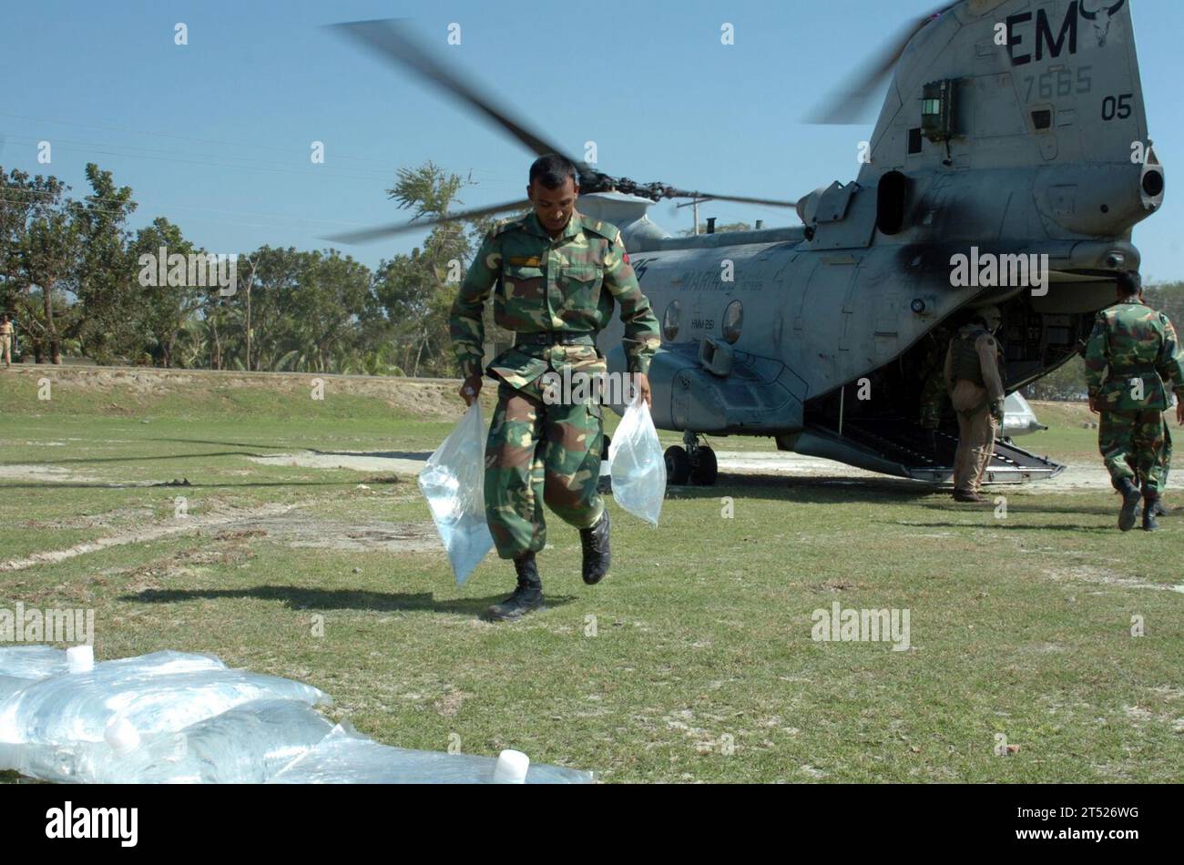 0711261831S-104 BANGLADESCH (26. November 2007) Ein Mitglied der Bangladesch-Armee hilft, Säcke mit gereinigtem Wasser von einem CH-46 Sea Knight zu entladen, der dem amphibischen Angriffsschiff USS Kearsarge (LHD 3) zugeordnet ist. Kearsarge und die 22. Marine Expeditionary Unit leisten humanitäre Hilfe für die Opfer des Zyklons Sidr, der am 15. November Bangladesch durchbrach. Die Bemühungen des Verteidigungsministeriums sind Teil einer größeren Reaktion der Vereinigten Staaten, die vom US-Außenministerium und der US-Agentur für internationale Entwicklung koordiniert wird. US Navy Stockfoto