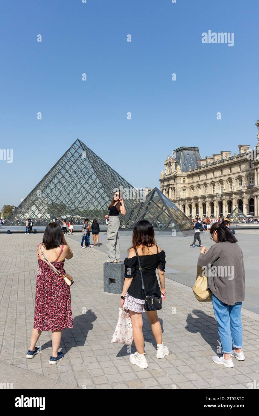 Posieren für Fotos im Louvre Museum (Musee du Louvre) und der Leoh Ming Pyramide, Place du Carrousel, Paris, Île-de-France, Frankreich Stockfoto