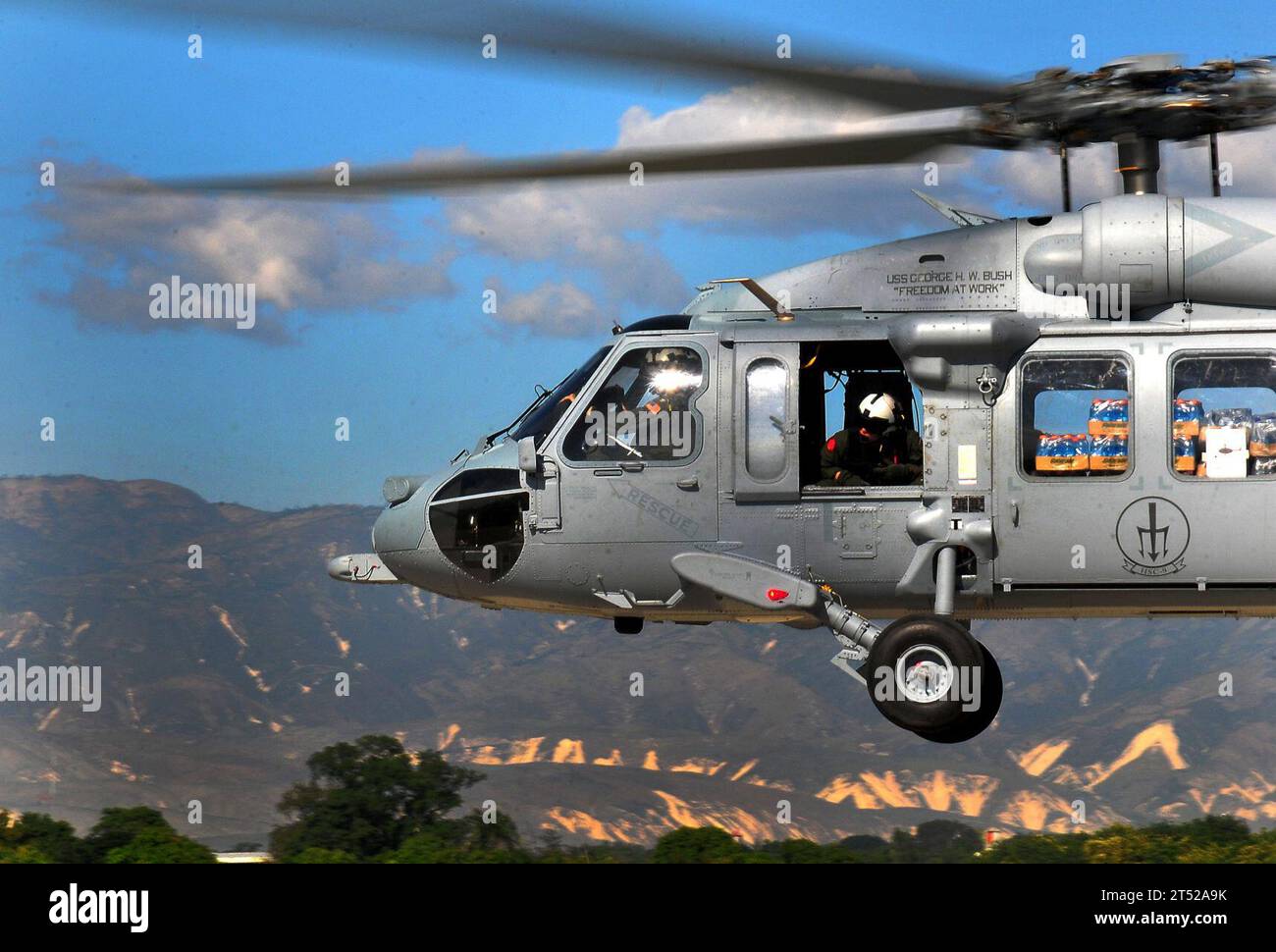 1001154774B-969 PORT-AU-PRINCE, Haiti (15. Januar 2010) Ein SH-60F Sea Hawk Hubschrauber, der den Red Lions of Helicopter Anti-U-Boot Squadron (HS) 15 zugewiesen ist, liefert Wasser und Vorräte an Haiti als Teil der Rettungs- und Hilfsmaßnahmen. Carl Vinson und Carrier Air Wing (CVW) 17 führen humanitäre und Katastrophenhilfe in Haiti als Reaktion auf die Erdbebenkatastrophe vom 12. Januar 2010 durch. Marineblau Stockfoto