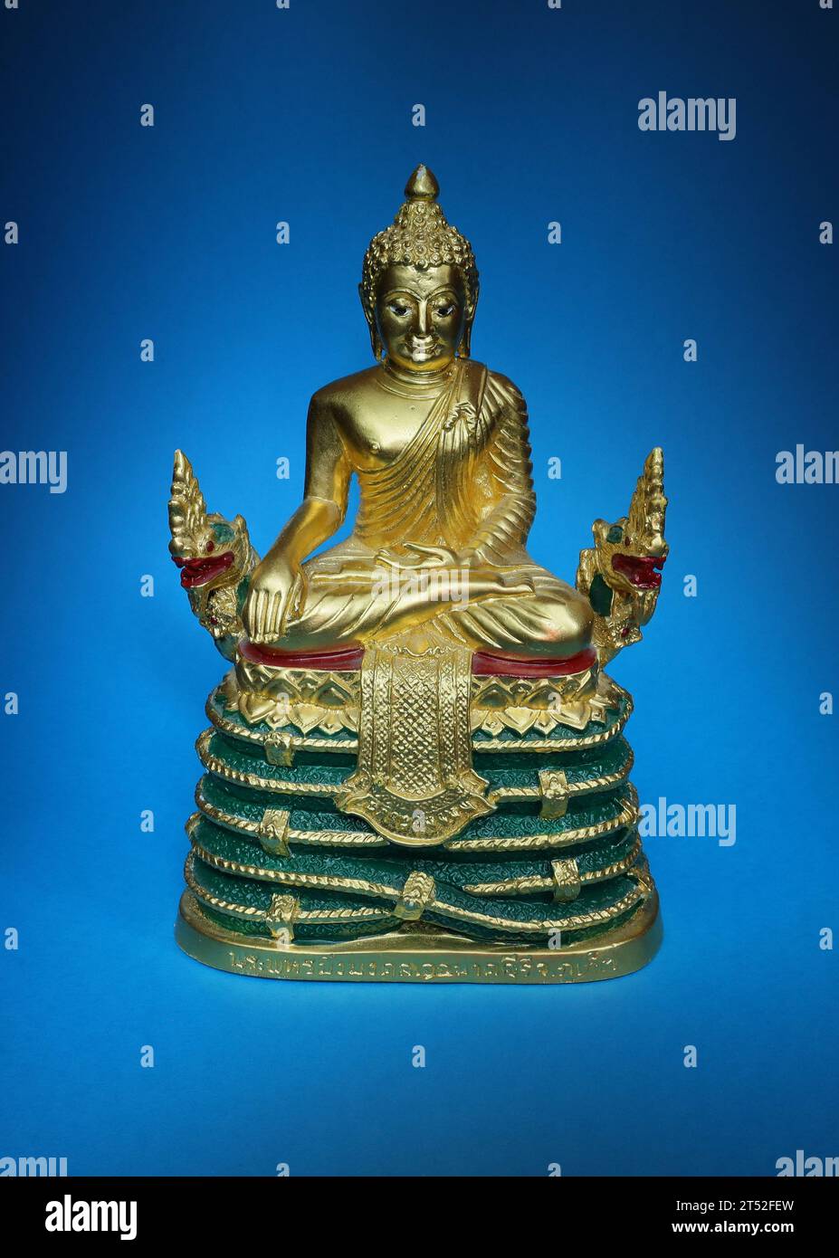 Golden sitzender Buddha mit der rechten Hand auf dem Knie vor blauem Hintergrund. Stockfoto