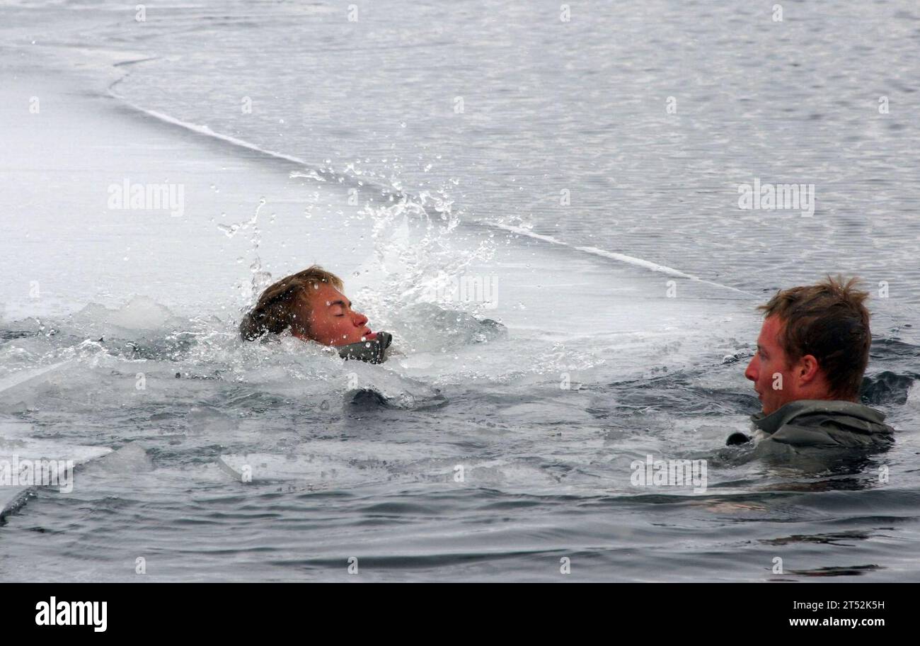 0904083714M-023 KODIAK, Alaska (8. April 2009) Ein SEAL Qualification Training Kandidat fällt während einer Erwärmungsübung in fast gefriertem Wasser durch das Eis. Die Kandidaten absolvierten die Übung zur Erwärmung, nachdem sie 48 Stunden in den Bergen Alaskas verbracht hatten, um zu lernen, wie man durch das raue Gelände navigiert und die kalten Bedingungen überlebt. Der 28-tägige Kurs für kaltes Wetter, der in Kodiak gelehrt wird, ist Teil eines einjährigen Prozesses, um ein US Navy SEAL zu werden. Marineblau Stockfoto