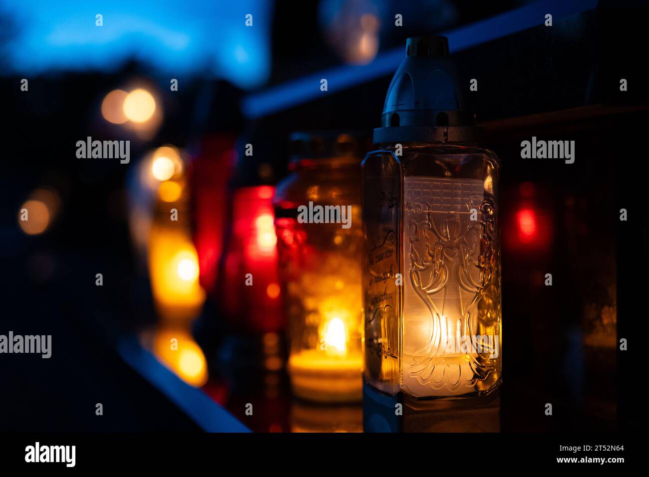 Kerzenlicht im Dunkeln mit unscharfem Bokeh-Hintergrund. Kerzen auf dem Friedhof bei Nacht. Selektiver Fokus. Geringe Tiefe des Feldes. Ganztägig. Stockfoto