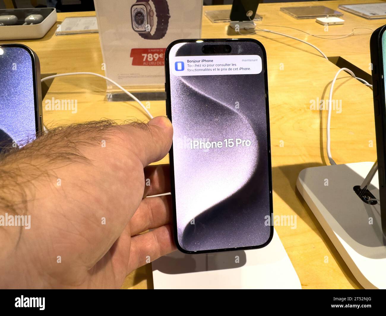 Straßburg, Frankreich - 1. Oktober 2023: Die männliche Hand eines Kunden hält das iPhone 15 Pro und bewundert die neue Titan-Konstruktion und die verbesserten CPU- und GPU-Leistung Stockfoto