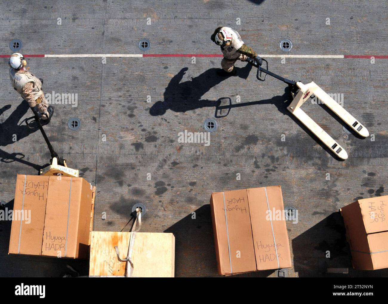 1103295538K-174 PAZIFISCHER OZEAN (29. März 2011) Marines stellen humanitäre Hilfsgüter auf dem Flugdeck des vorgelagerten amphibischen Angriffsschiffs USS Essex (LHD 2) auf. Essex arbeitet mit der 31st Marine Expeditionary Unit (31st MEU) vor der Küste von Kesennuma im Nordosten Japans, um die Operation Tomodachi zu unterstützen. Marineblau Stockfoto