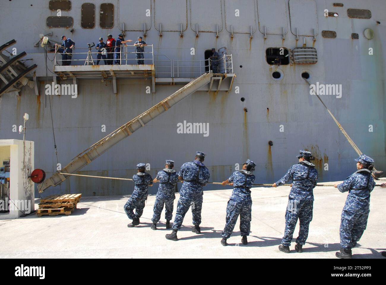 110724QL533-004 SOUDA BAY, Griechenland (24. Juli 2011) Linienführer, die der U.S. Naval Support Activity Souda Bay zugeteilt sind, helfen, während eines routinemäßigen Hafenbesuchs für das Amphibienangriffsschiff USS Bataan (LHD 5) am Marathi Pier eine Stirn zu positionieren. Marineblau Stockfoto