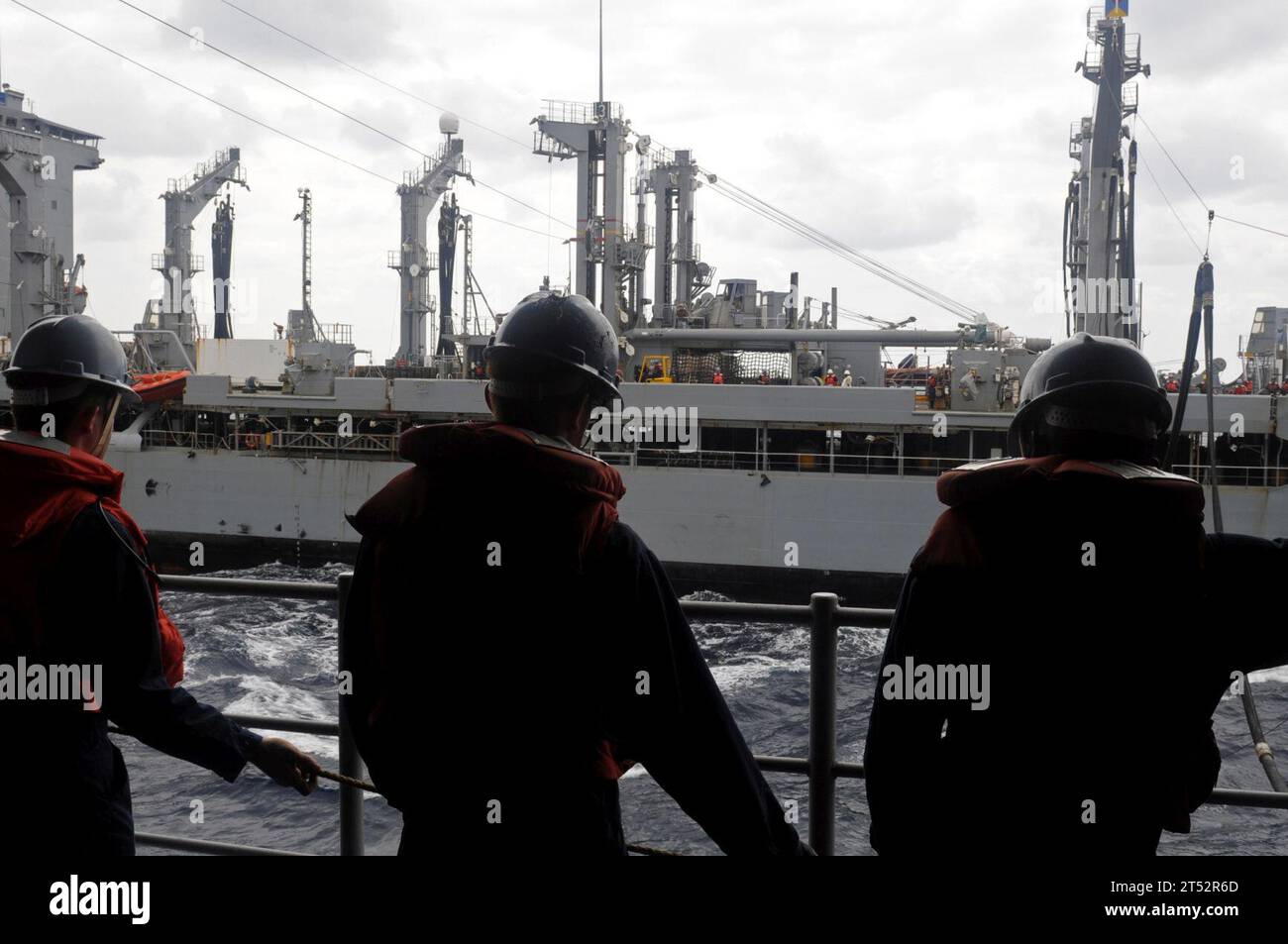 0909207280V-207 PACIFIC OCEAN (20. September 2009) Sailor steht an Bord des amphibischen Kommandoschiffs USS Blue Ridge (LCC 19) an der Linie, während der militärische Sealift Command-Flottenauffüllungsöler USNS John Ericsson (T-AO 194) ihre Botenlinie während einer Auffüllung auf See akzeptiert. Marineblau Stockfoto