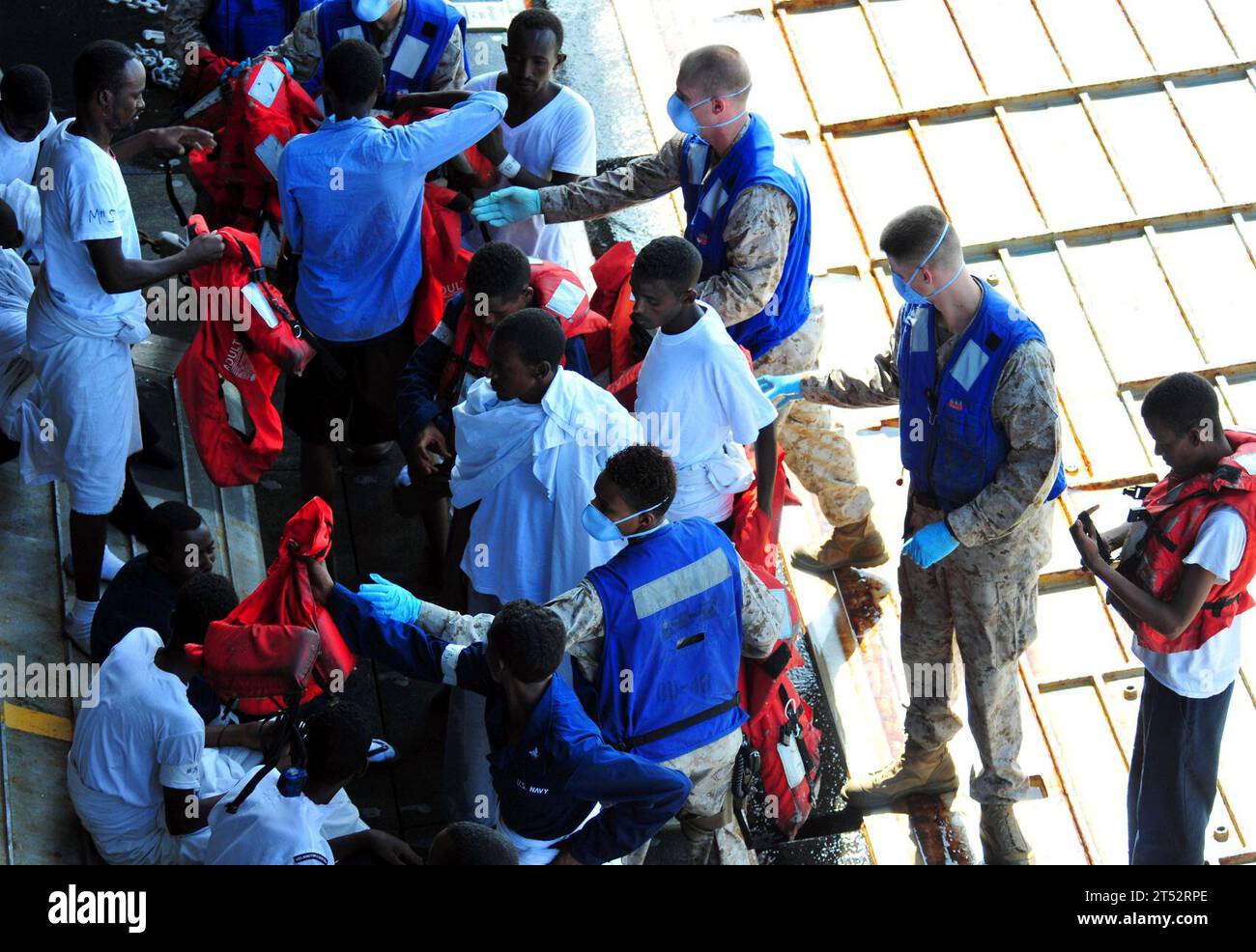 1009297948R-306 GULF OF ADEN (29. September 2010) Seeleute und Marines helfen den geretteten Personen, ihre Rettungswesten zu entfernen, während sie an Bord des amphibischen Hafenlandeschiffs USS Pearl Harbor (LSD 52) gehen. Sie wurden vom 27. September 81 von Seeleuten gerettet, die dem Raketenzerstörer USS Winston S. Churchill (DDG) zugeteilt waren, nachdem ihr Boot im Golf von Aden kenterte. Sie erhielten Nahrung, Wasser und medizinische Versorgung, bevor sie nach Pearl Harbor gebracht wurden. Pearl Harbor ist Teil der Combined Task Force (CTF) 151, einer multinationalen Task Force, die im Januar 2009 gegründet wurde, um Operationen zur Bekämpfung der Piraterie in und aro durchzuführen Stockfoto