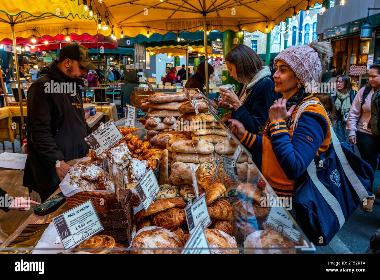 Junge Leute kaufen Brot bei Olivier's Bakery, Borough Market, London, Großbritannien Stockfoto