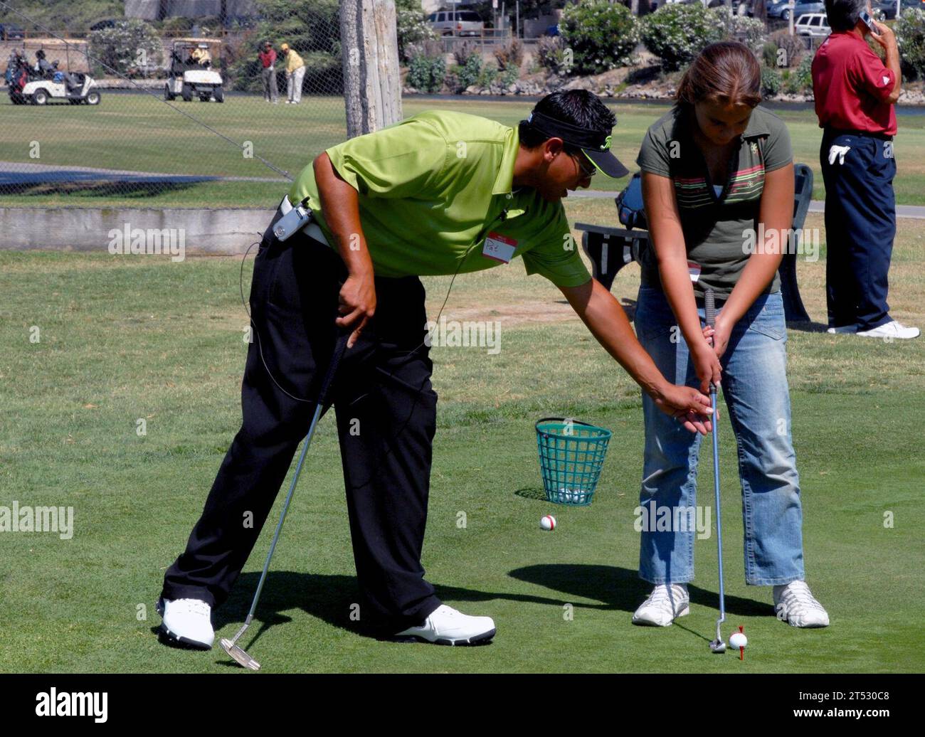 0707189604C-009 CHULA VISTA, KALIFORNIEN (18. Juli 2007) - Golfprofi Pat Diaz gibt einem jungen Golfer einige Tipps zum Putting auf dem städtischen Golfplatz Chula Vista. PIN Pals Junior Links, eine gemeinnützige Organisation, hat eine Partnerschaft mit Armed Services YMCA aus San Diego gegründet und bietet kostenlose Junior-Golfkurse für Jungen und Mädchen im Alter von 10 bis 13 Jahren, deren Eltern dem Land dienen. Jede Session wird von einem PGA-Profi durchgeführt und trifft sich einmal pro Woche für zwei, vierwöchige Sitzungen. Dabei werden die Grundlagen des Puttens, Chipping, Pitching und des vollen Swing behandelt. US Navy Stockfoto