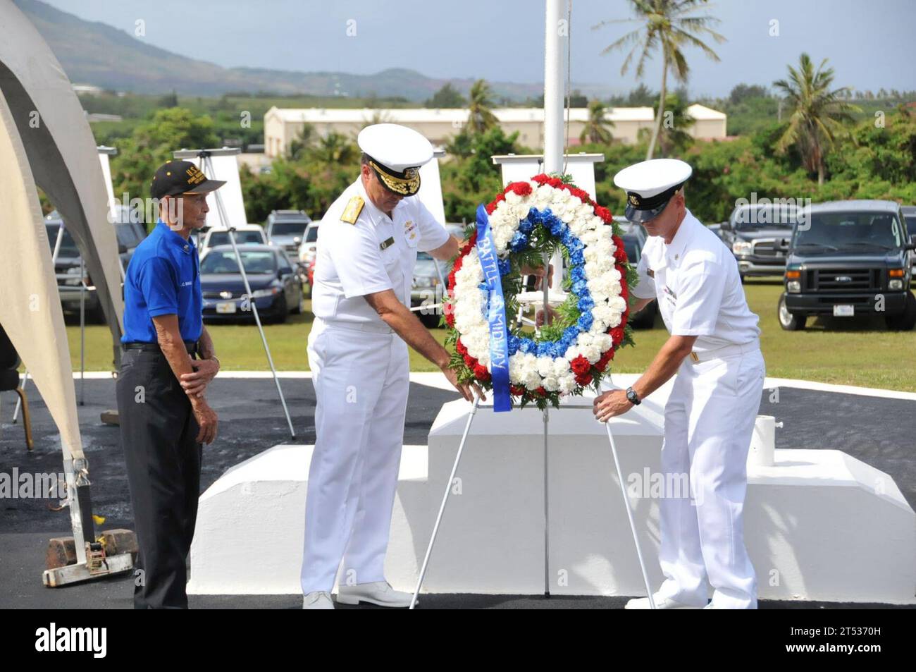 110603RR409-712 SANTA RITA, Guam (3. Juni 2011) Kriegsveteran Manuel Diaz, links, sieht als Hintermann ADM. Paul Bushong, Mitte, Kommandeur der Joint Region Marianas (JRM), und JRM-Kommandomeister Paul Kingsbury positionieren den Gedenkkranz während einer Zeremonie zum 69. Jahrestag der Schlacht von Midway im WWII Memorial Park auf der US Naval Base Guam. (U.S. Navy Stockfoto