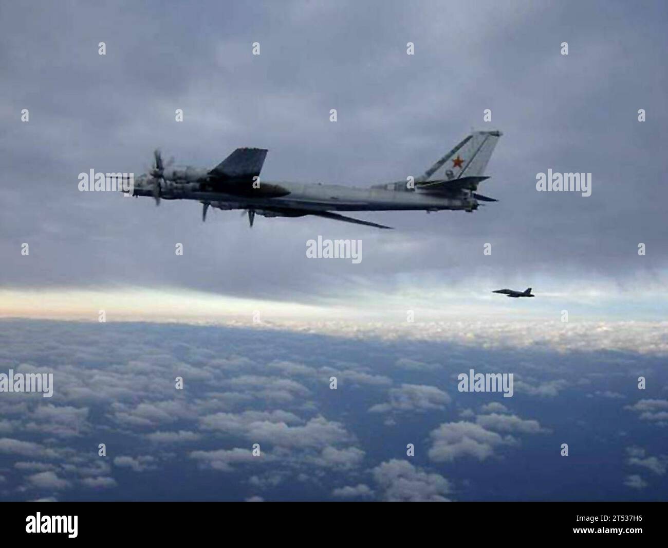080209XXXXX-001 PACIFIC (2. Februar 2008) ein F/A-18 Hornet von Carrier Air Wing (CVW) 11, das an Bord des Flugzeugträgers USS Nimitz (CVN 68) eingestiegen ist, eskortiert am 9. Februar 2008 ein russisches Tu-95 Bear, Langkampfbomberflugzeug südlich Japans. Der Bomber näherte sich der Nähe des Trägers, was zum Abfangen des Jagdflugzeugs führte. Nimitz durchquerte den Westpazifik zu einem regelmäßigen geplanten Einsatz, als sich der Vorfall ereignete. Stockfoto