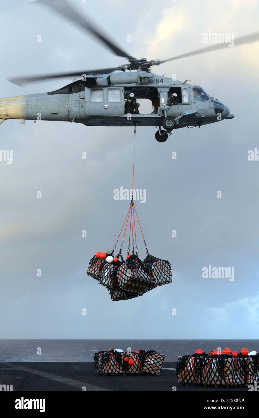0910129132C-023 PACIFIC OCEAN (12. Oktober 2009) ein MH-60S Sea Hawk Hubschrauber, der den Blackjacks of Helicopter Sea Combat Squadron (HSC) 21 zugeordnet ist, lädt während einer vertikalen Auffüllung Fracht auf das Flugdeck des Flugzeugträgers USS Ronald Reagan (CVN 76). Die Ronald Reagan Carrier Strike Group ist auf einem routinemäßigen Einsatz im Zuständigkeitsbereich der 7. US-Flotte. Stockfoto