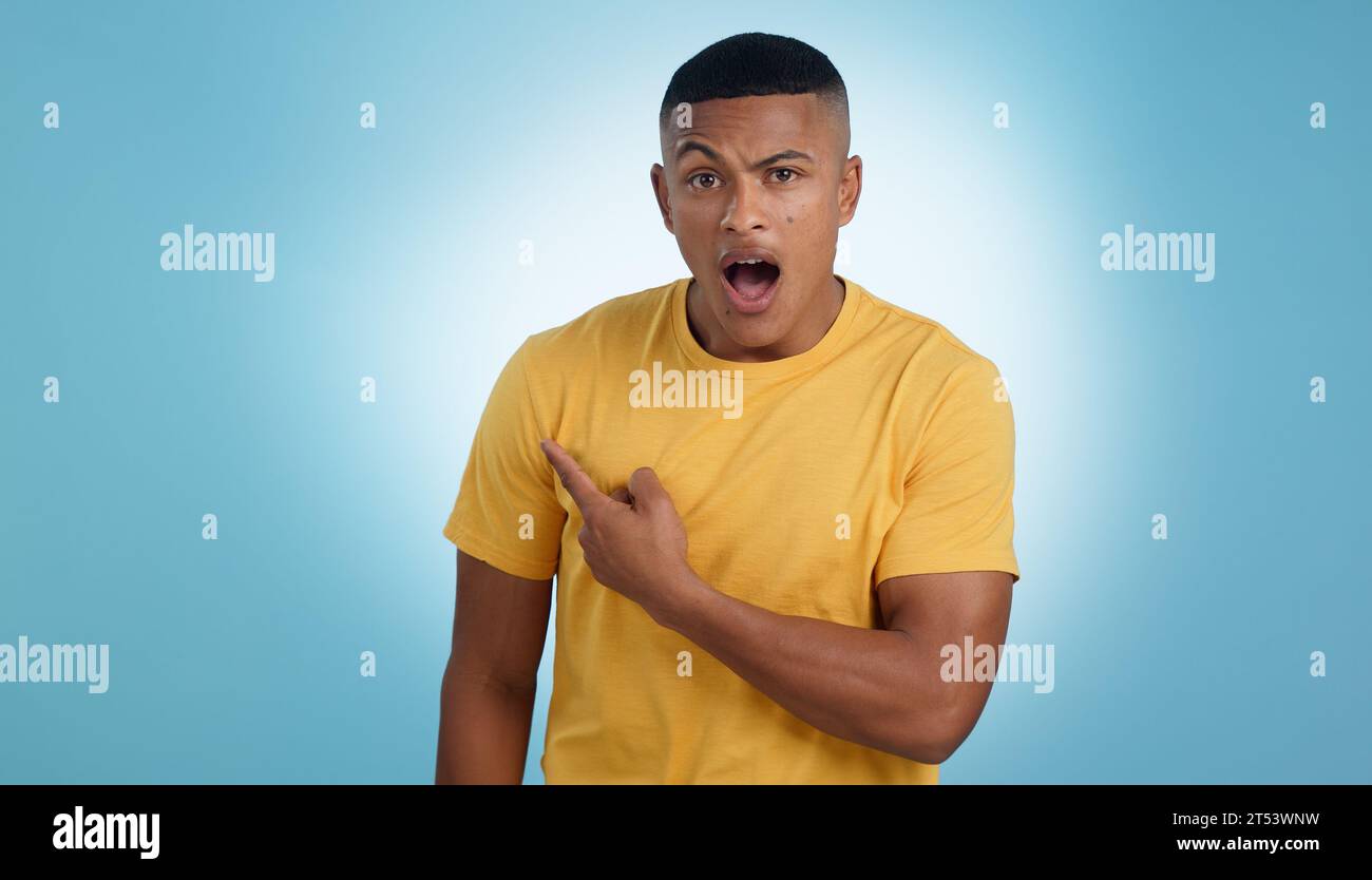 Zeigen, Schocken und Porträt eines Mannes in einem Studio mit Mockup für Marketing, Werbung oder Werbung. Überraschung, Wow und junger Mann mit einer Show Stockfoto