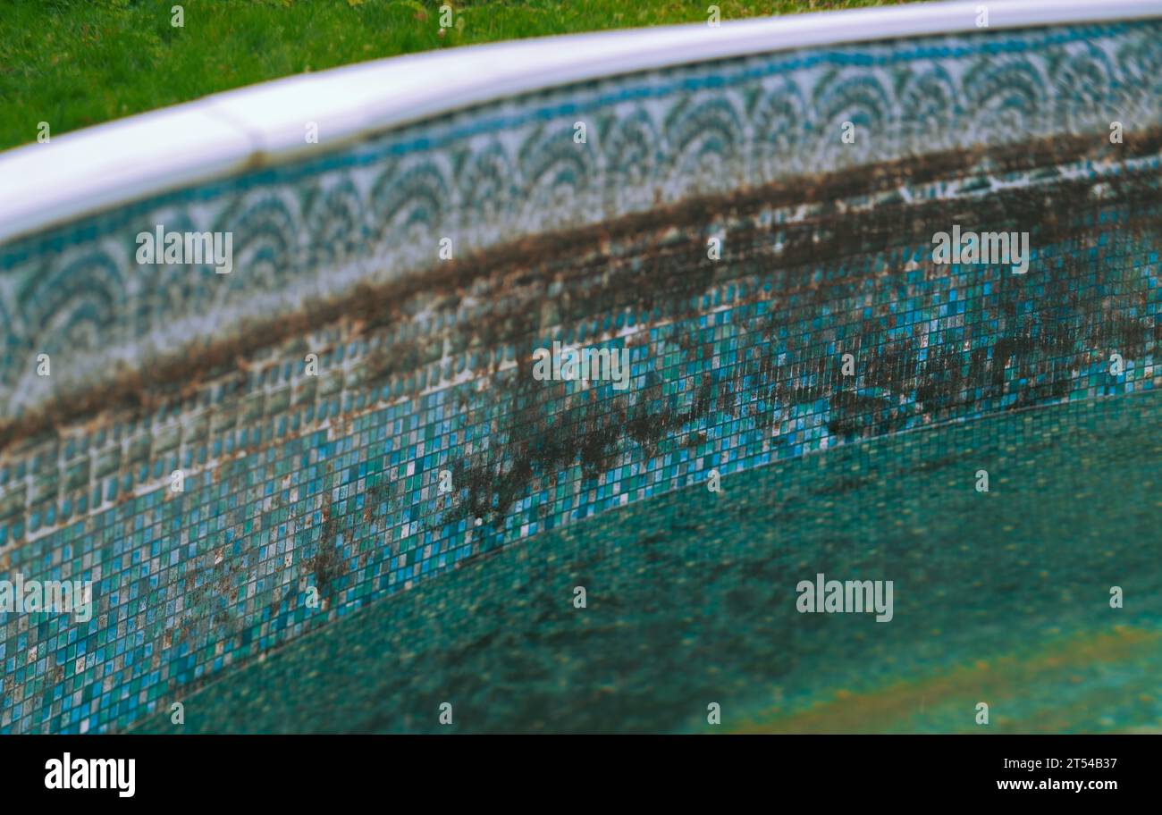 Ein Pool, der mit Schmutz und Schlamm bedeckt ist Stockfoto