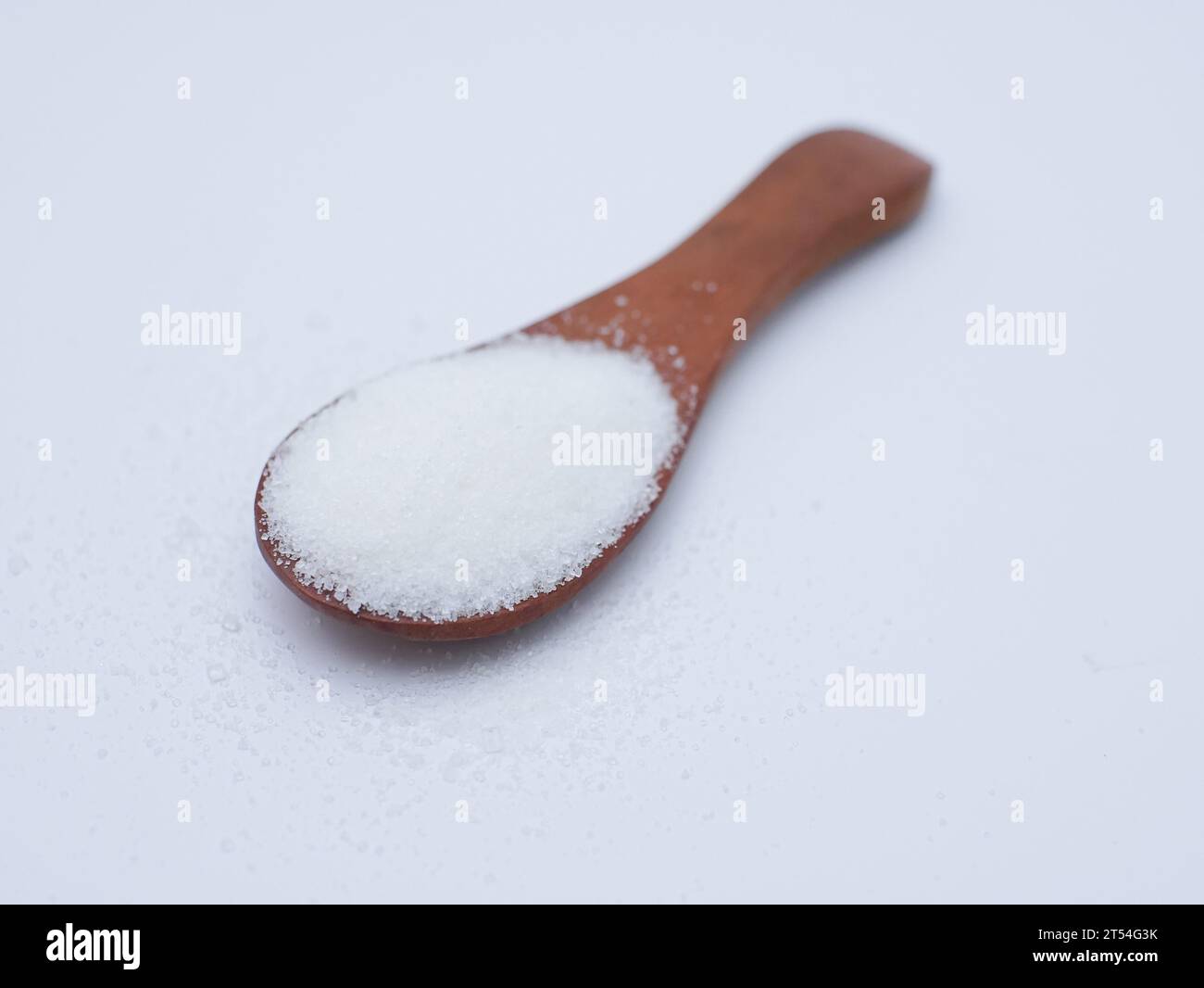 Zucker im Holzlöffel isoliert auf weiß. Ungesunde Ernährung, Bewusstsein und Stop Diabetes Konzept Stockfoto