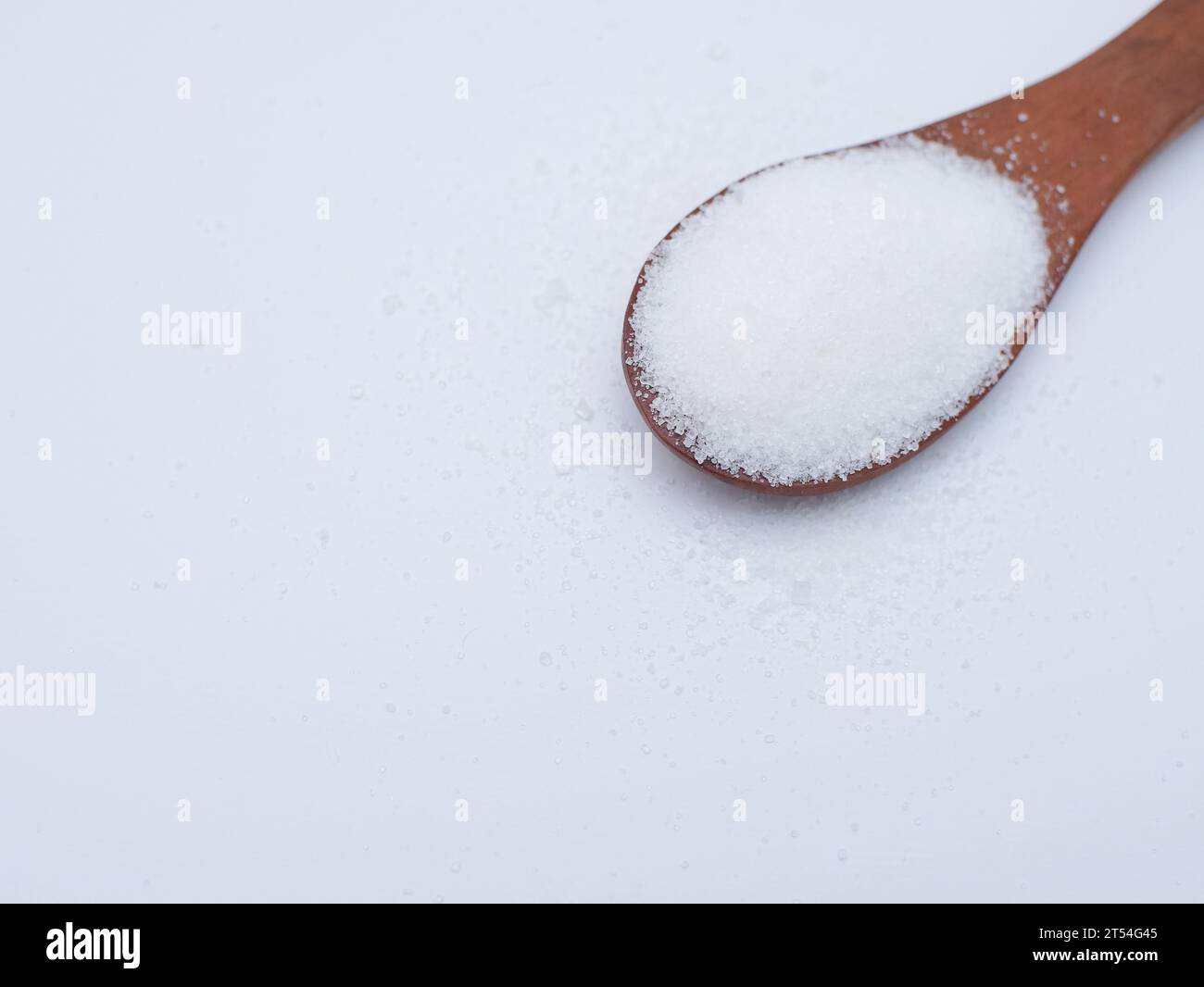 Zucker im Holzlöffel isoliert auf weiß. Ungesunde Ernährung, Bewusstsein und Stop Diabetes Konzept. Stockfoto