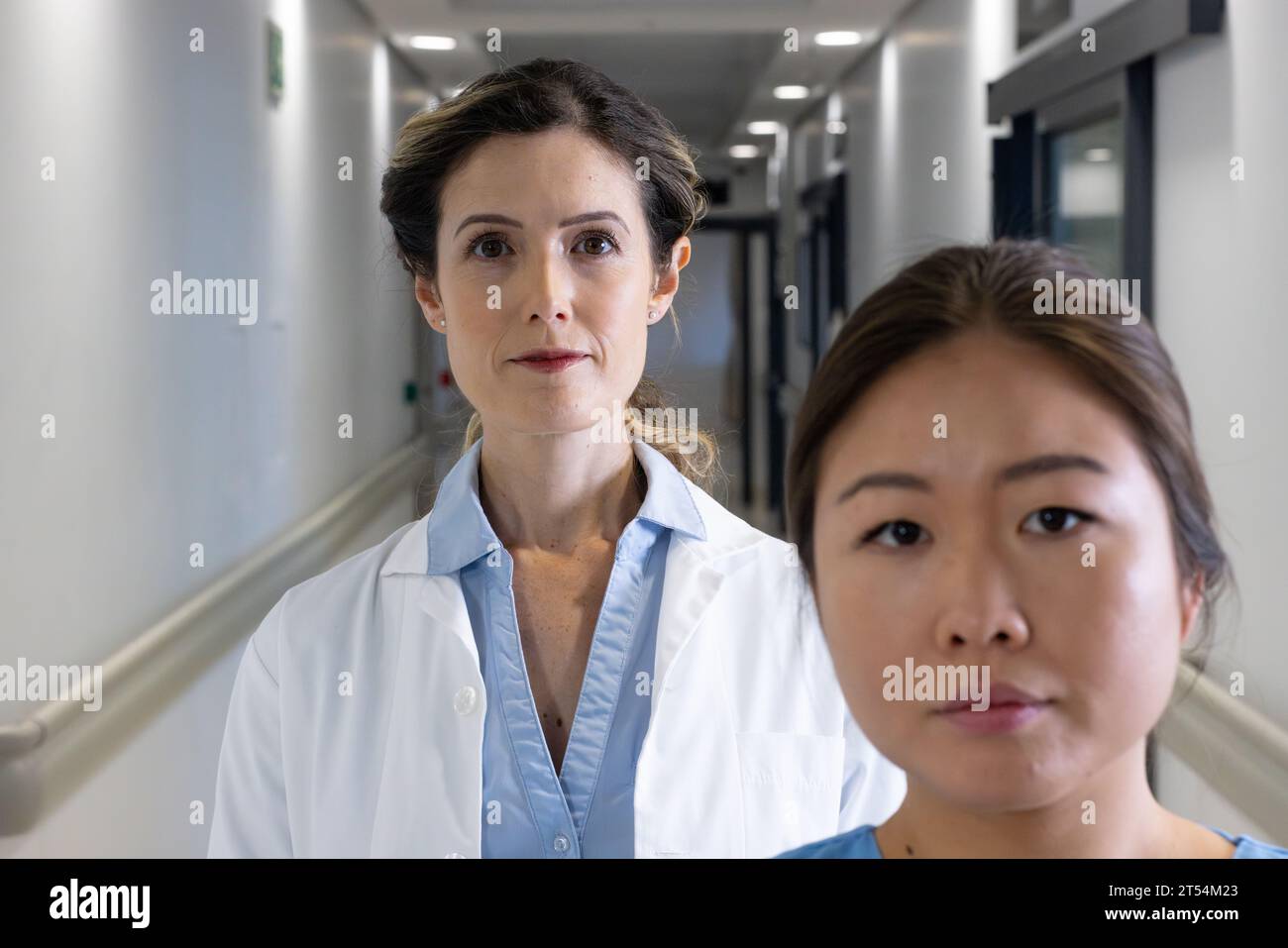 Zwei verschiedene Ärztinnen stehen im Krankenhauskorridor Stockfoto