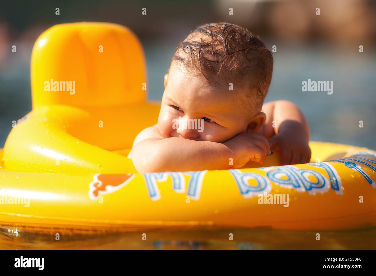 Niedlicher kleiner Junge in einem Babyschwimmring, schwimmt im Meer und genießt das Wasser und die Sommerzeit. Stockfoto