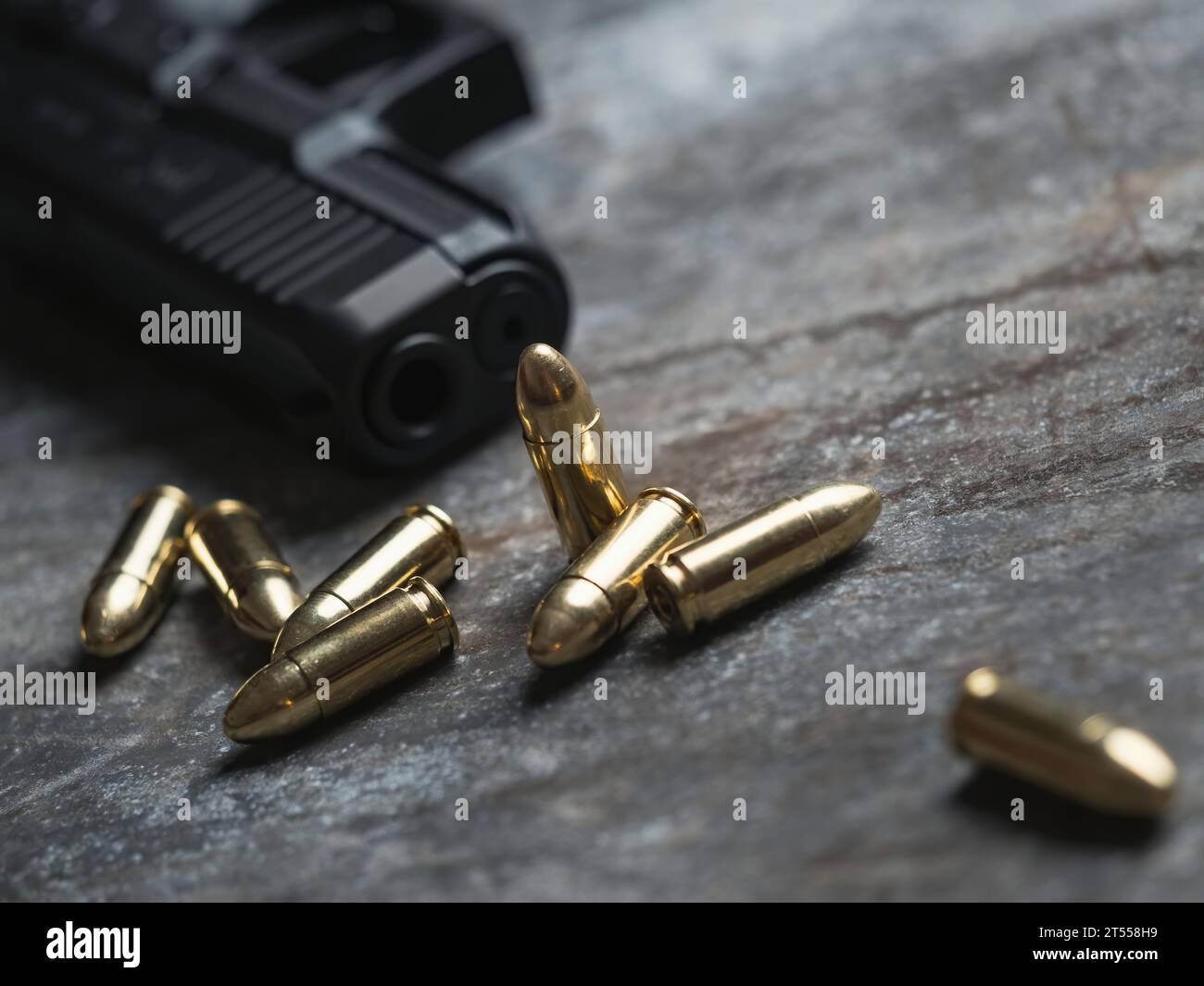 Handfeuerwaffe mit Munition auf dunklem Hintergrund. 9-mm-Pistole, Militärwaffe und ein Haufen Munition am Metalltisch. Stockfoto