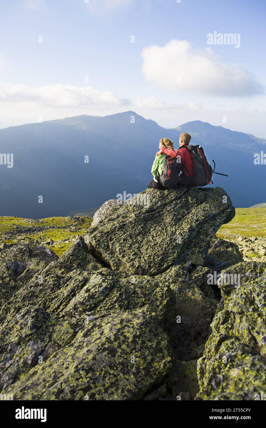 Foto eines Wanderpaares, das Hände hält, während er auf dem Mount Washington sitzt. Stockfoto