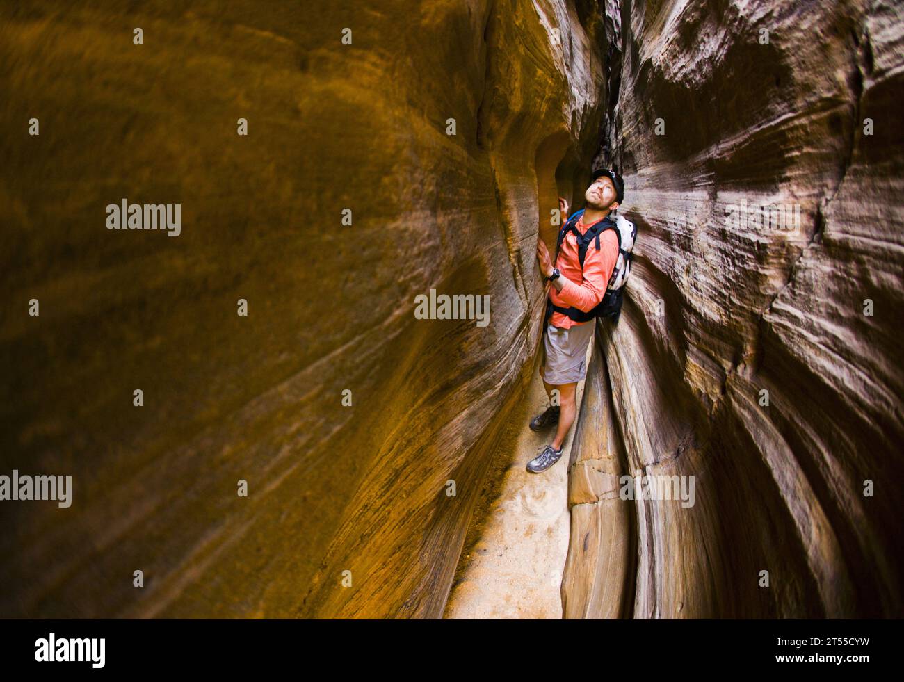 Männlicher Wanderer, der einen schmalen Sandsteinschlucht erkundet. Stockfoto
