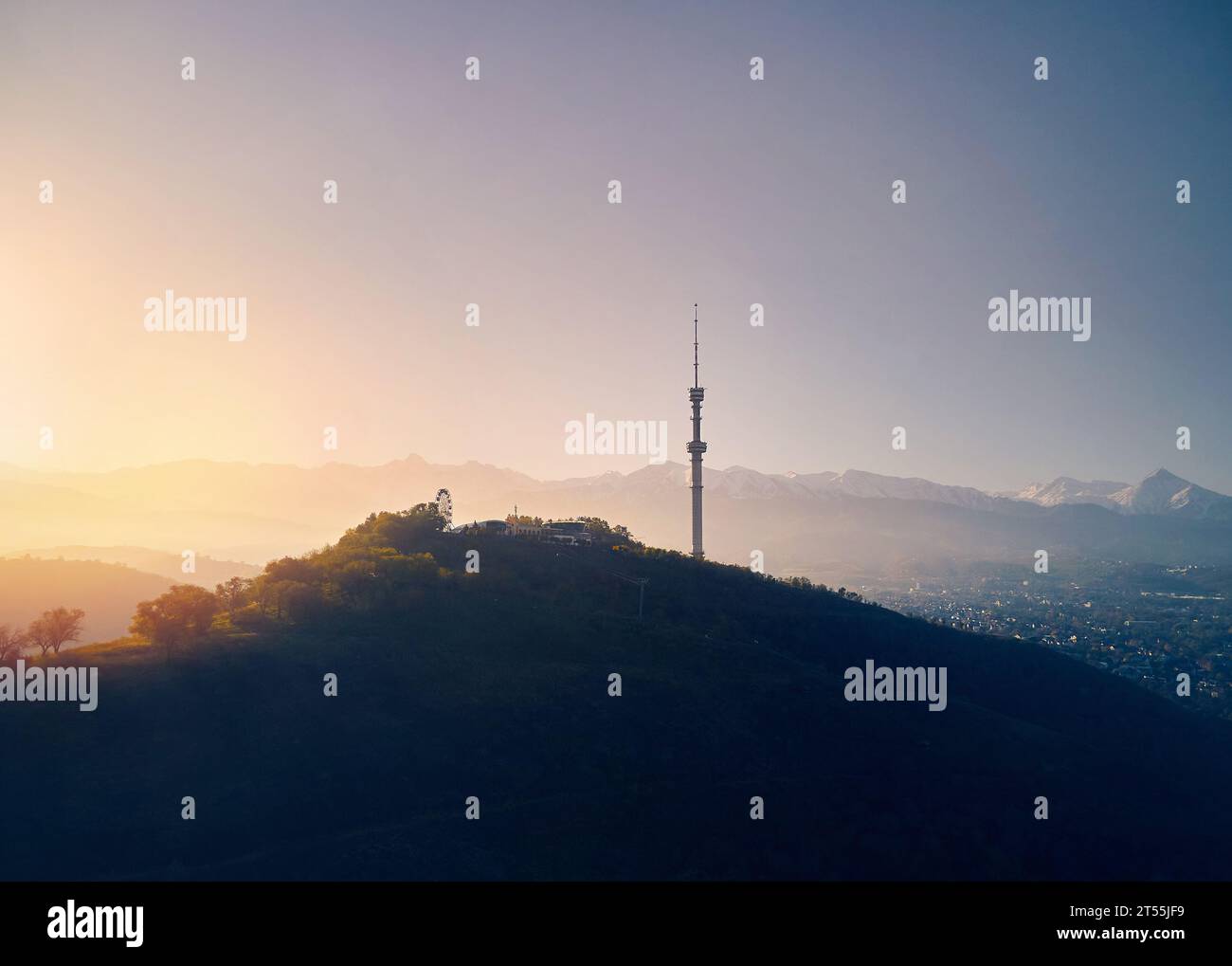 Luftdrohnenaufnahme von Symbol Almaty City hoher Fernsehturm und Park auf dem Koktobe Hügel vor Schnee Berge bei Sonnenaufgang in Kasachstan Stockfoto