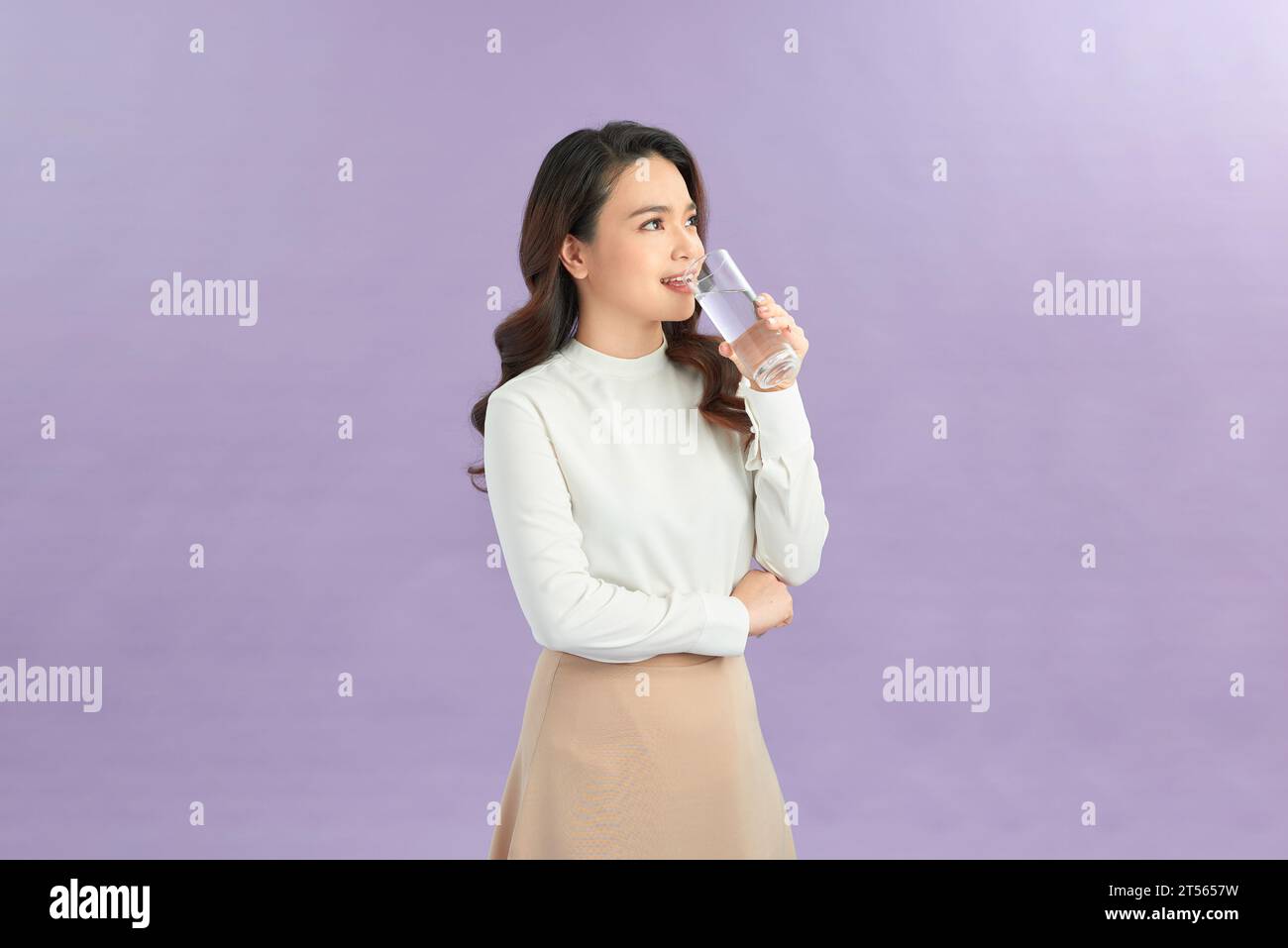 Junge Frau hält klare, frische, stille Wasser aus Glas Stockfoto