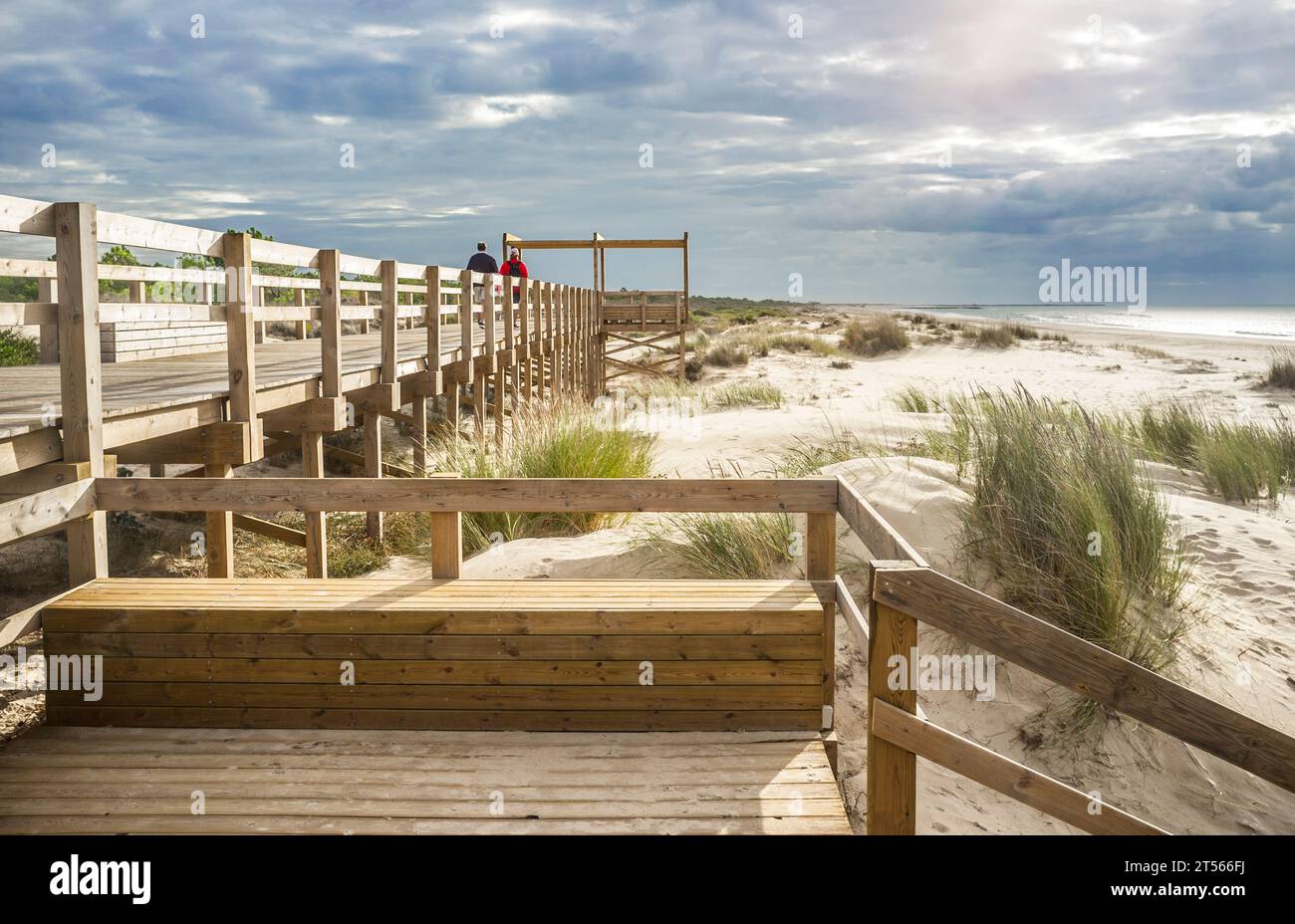 Besucher spazieren über eine hölzerne Fußgängerbrücke am Strand Monte Gordo, Vila Real de Santo Antonio, Portugal Stockfoto