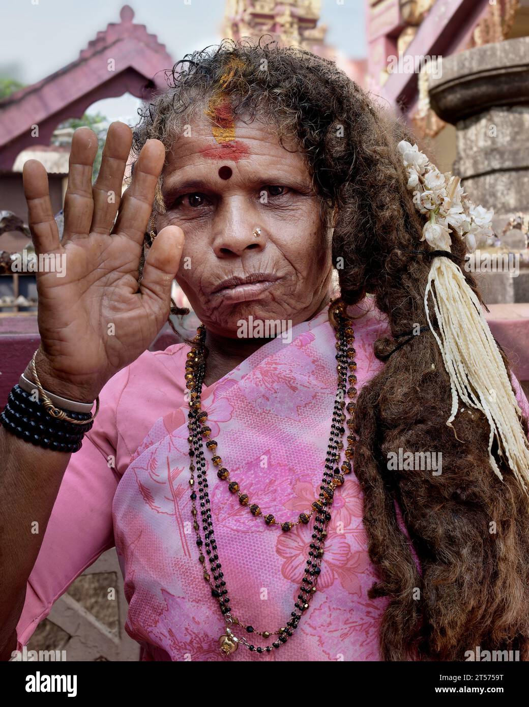 Eine asketische Frau oder Sadhvi mit matten Haaren, oft ein Symbol für die Hingabe an die Göttin Yellamma, die ihre Hand zum Segen hebt; Nasik, Maharashtra, Indien Stockfoto