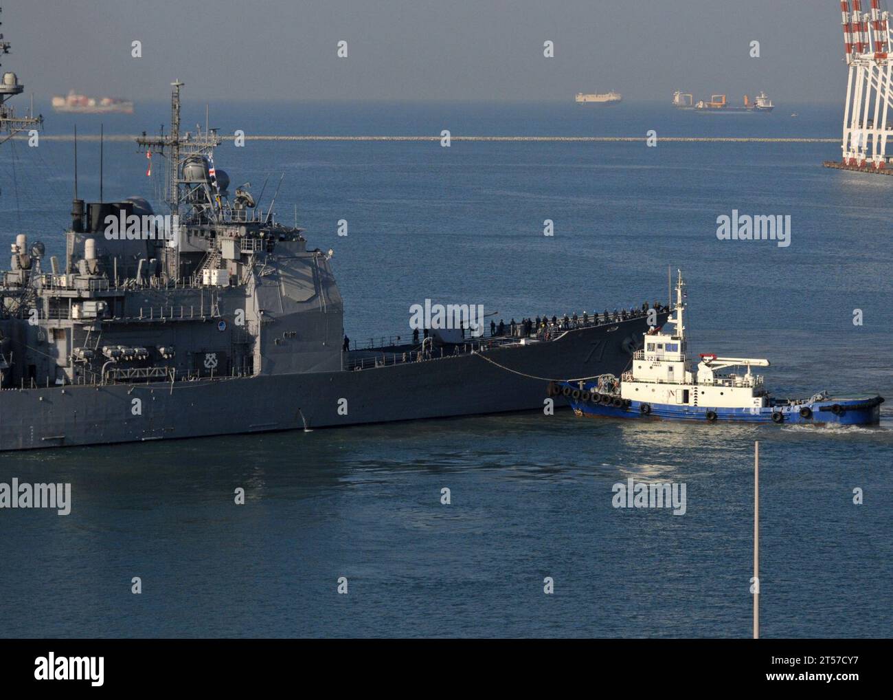 US Navy der Lenkraketenkreuzer der Ticonderoga-Klasse USS Cape St. George (CG 71) wird von einer tugboat.jpg aus dem Hafen geführt Stockfoto