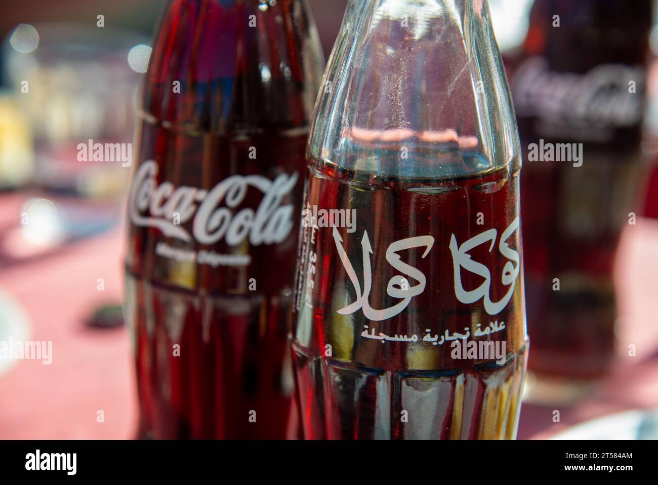 Zwei Flaschen Coca Cola. Ein arabisch und einer auf Englisch. Stockfoto